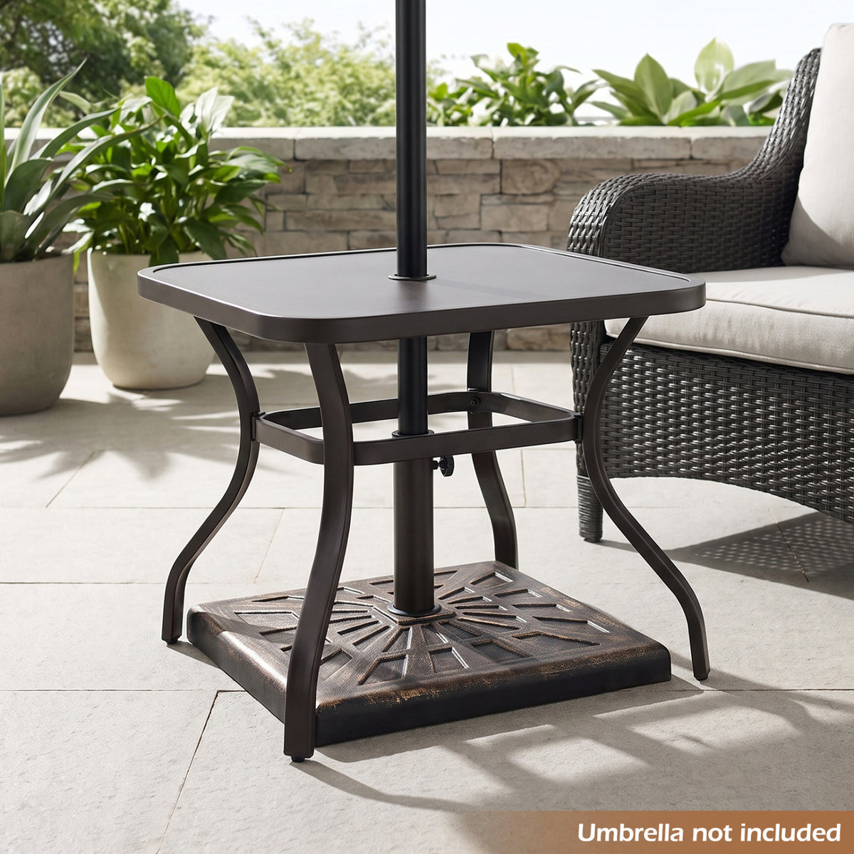 Antiqued bronze patterned umbrella base beneath a patio table, angled outdoor view