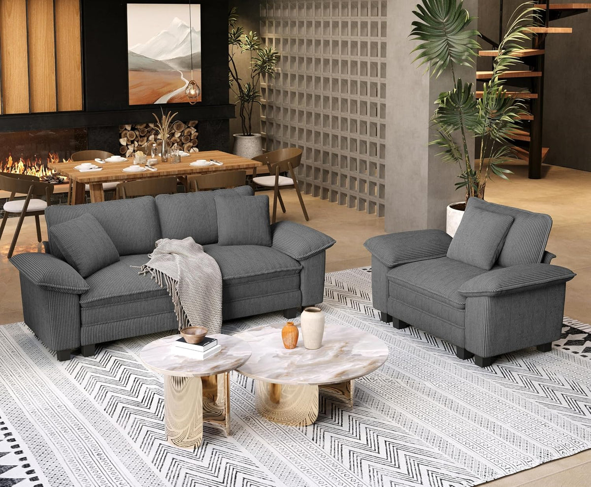 Gray three-seat sofa and matching armchair on a patterned rug with dining area in background.