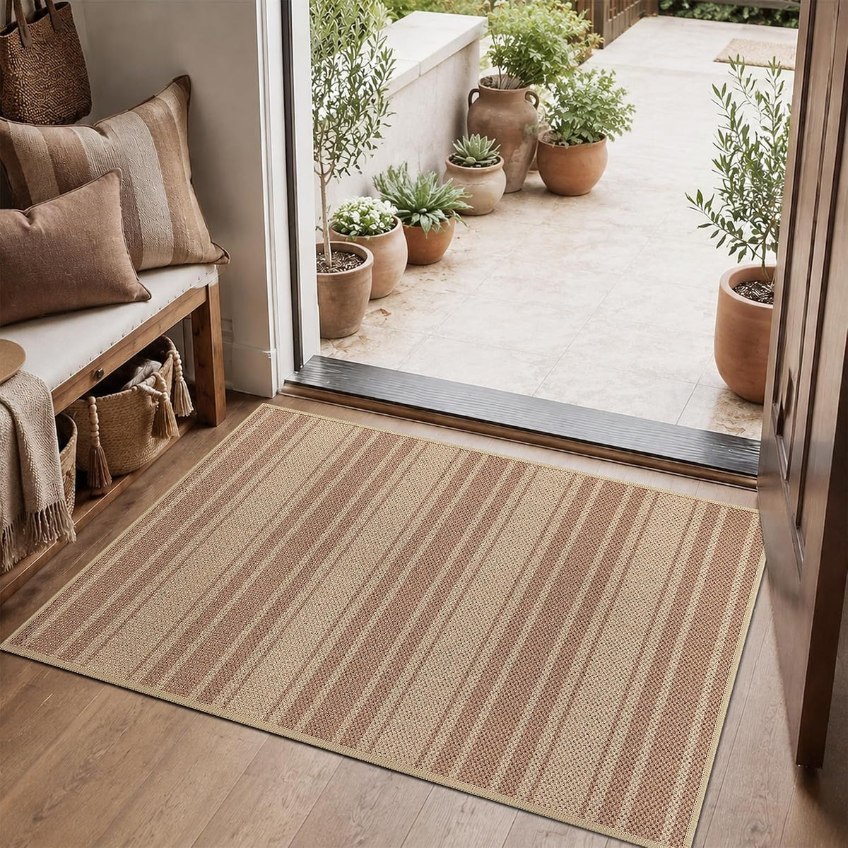 Rectangular rug placed at a sliding door threshold with clay pots outside and a cushioned bench inside.