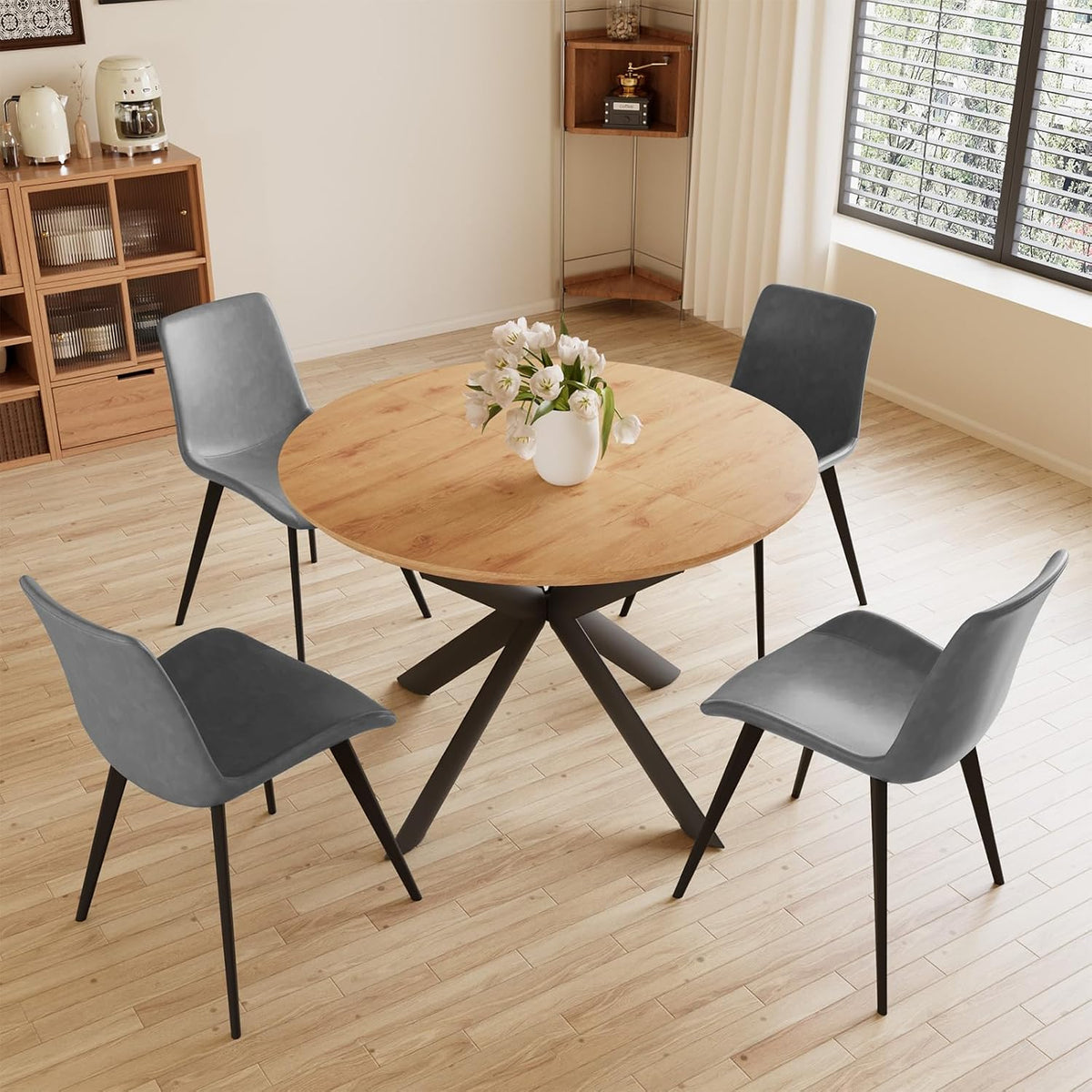 Round light-wood table with four gray PU chairs set on a pale wood floor near a window