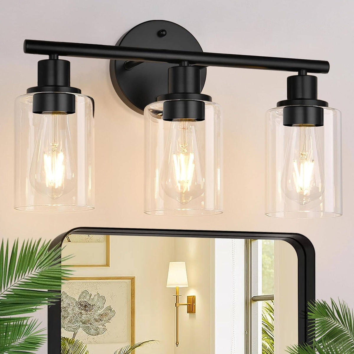 Close-up of three clear cylindrical glass shades and illuminated bulbs on a black metal vanity bar