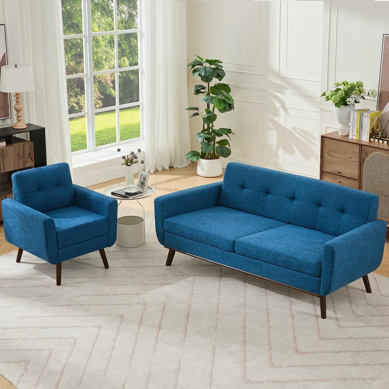 Bright living room with blue tufted loveseat and matching armchair on a light rug