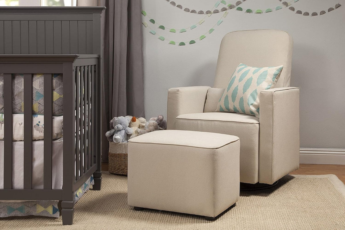 Cream glider chair and ottoman placed beside a grey crib in a nursery setting
