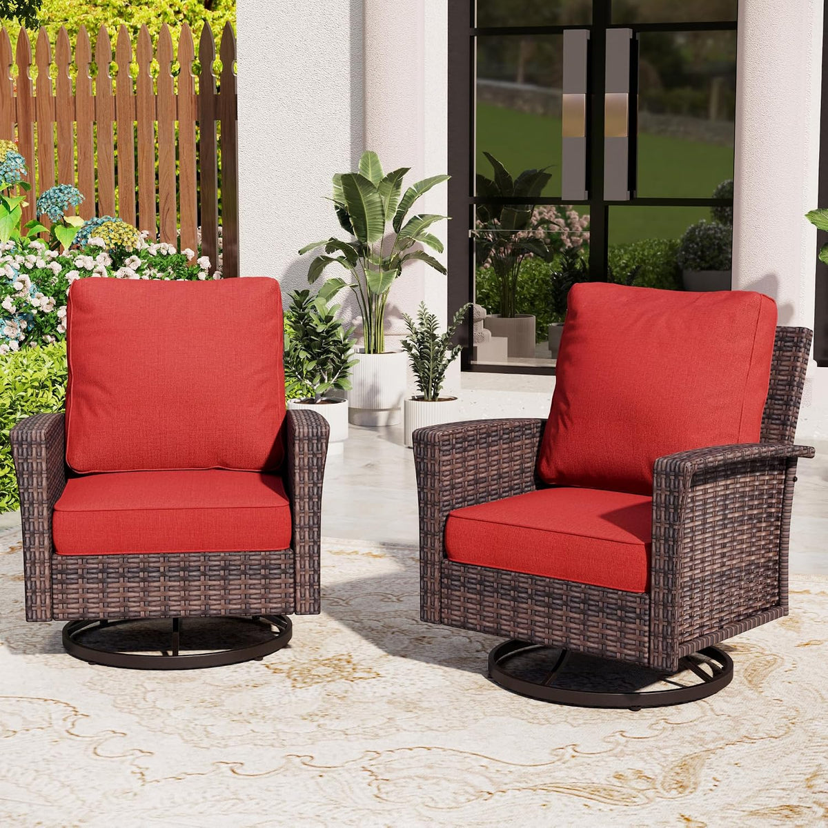 Pair of wicker swivel armchairs with thick red seat and back cushions on a patterned rug