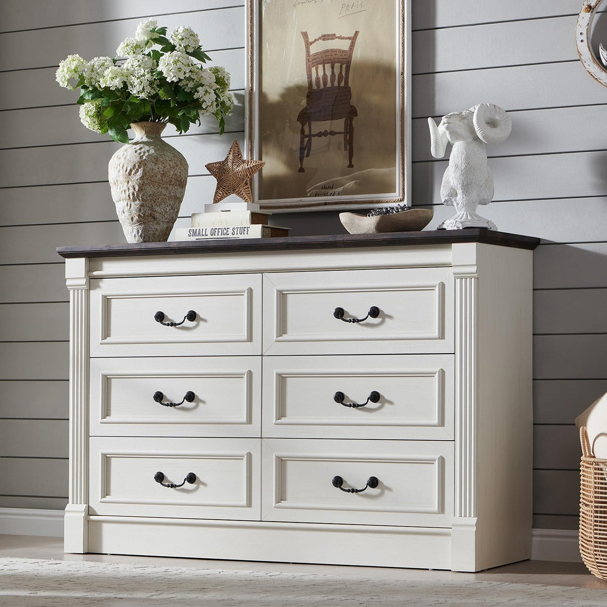 Front view of an antique-white dresser with six framed drawers and dark wood top, styled with decor.