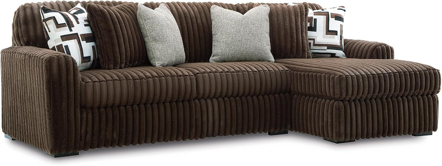 Angled side view of a chocolate brown corduroy chaise sofa section with patterned pillows