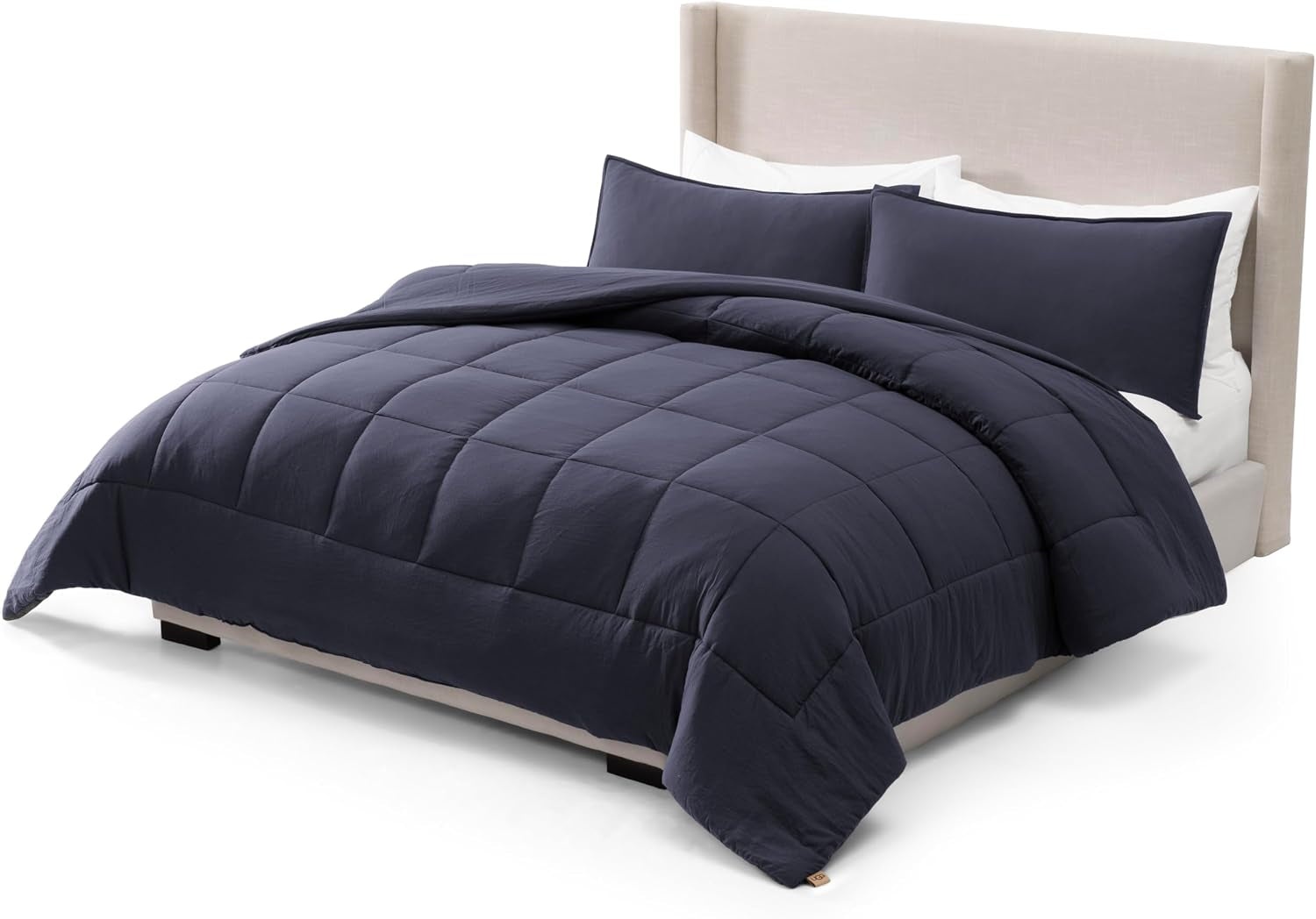 Straight-on view of a bed made with a dark navy box‑stitched comforter and two navy shams.