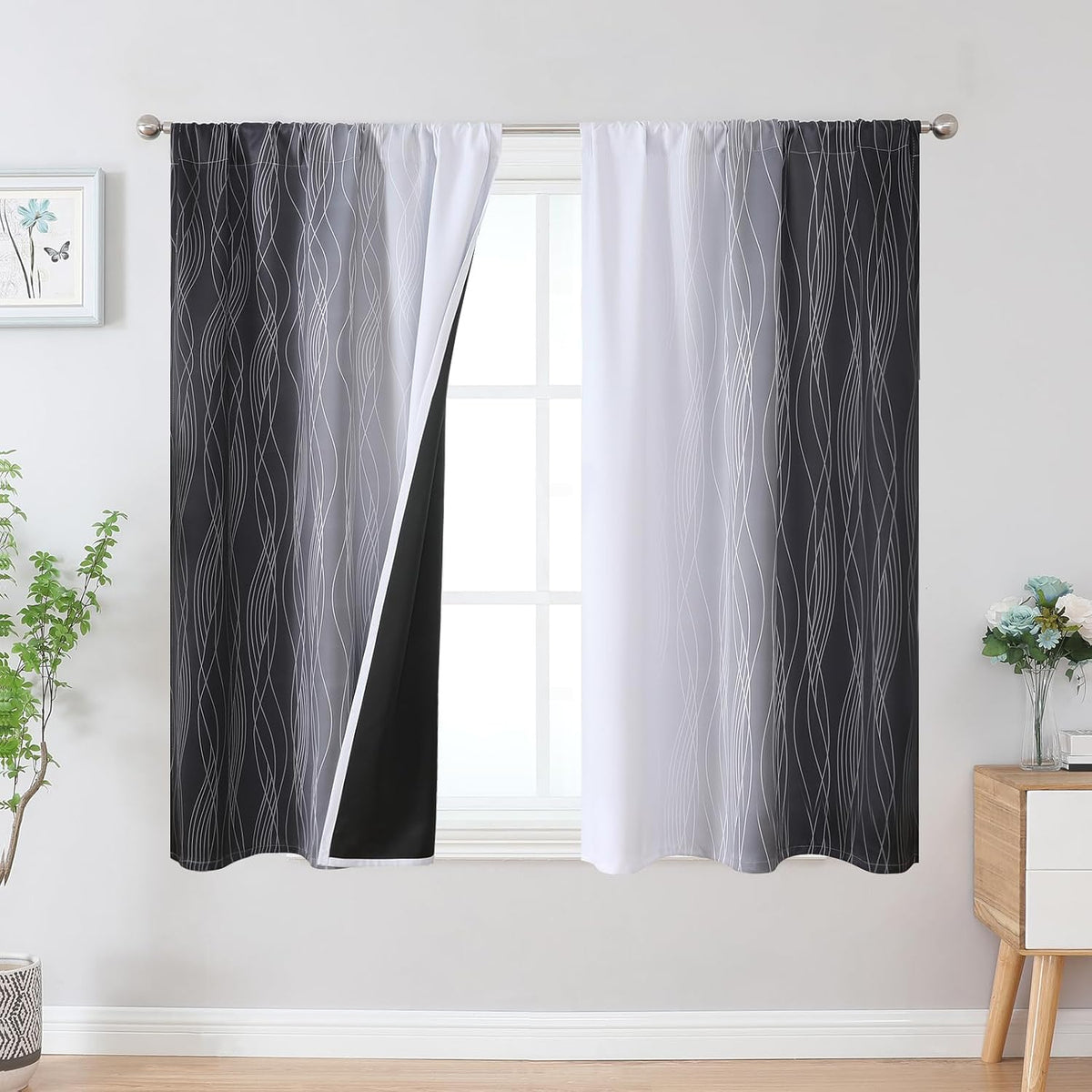 Window with black-to-white ombre drapes with wavy line pattern; left panel pulled back showing black lining.