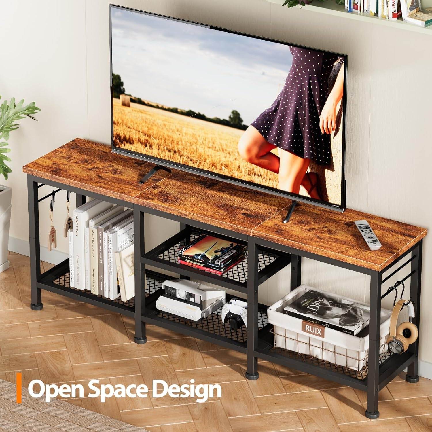 Styled living room view of TV console in rustic brown with open shelving holding books and accessories