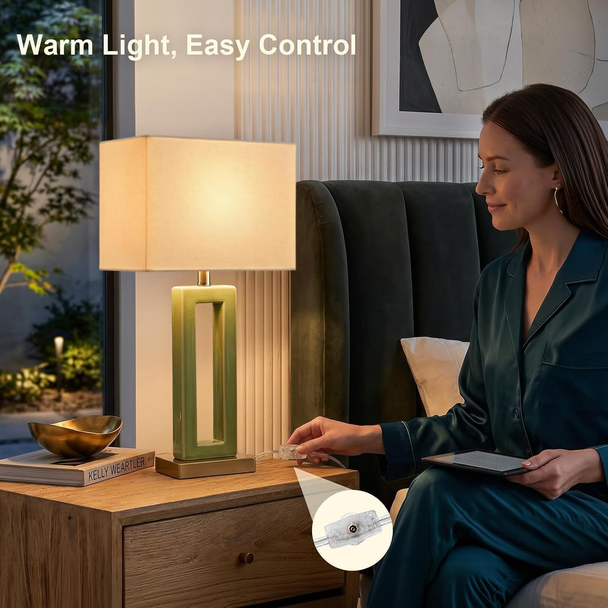 Person using the inline rotary switch on a green ceramic table lamp beside a bed with warm light visible