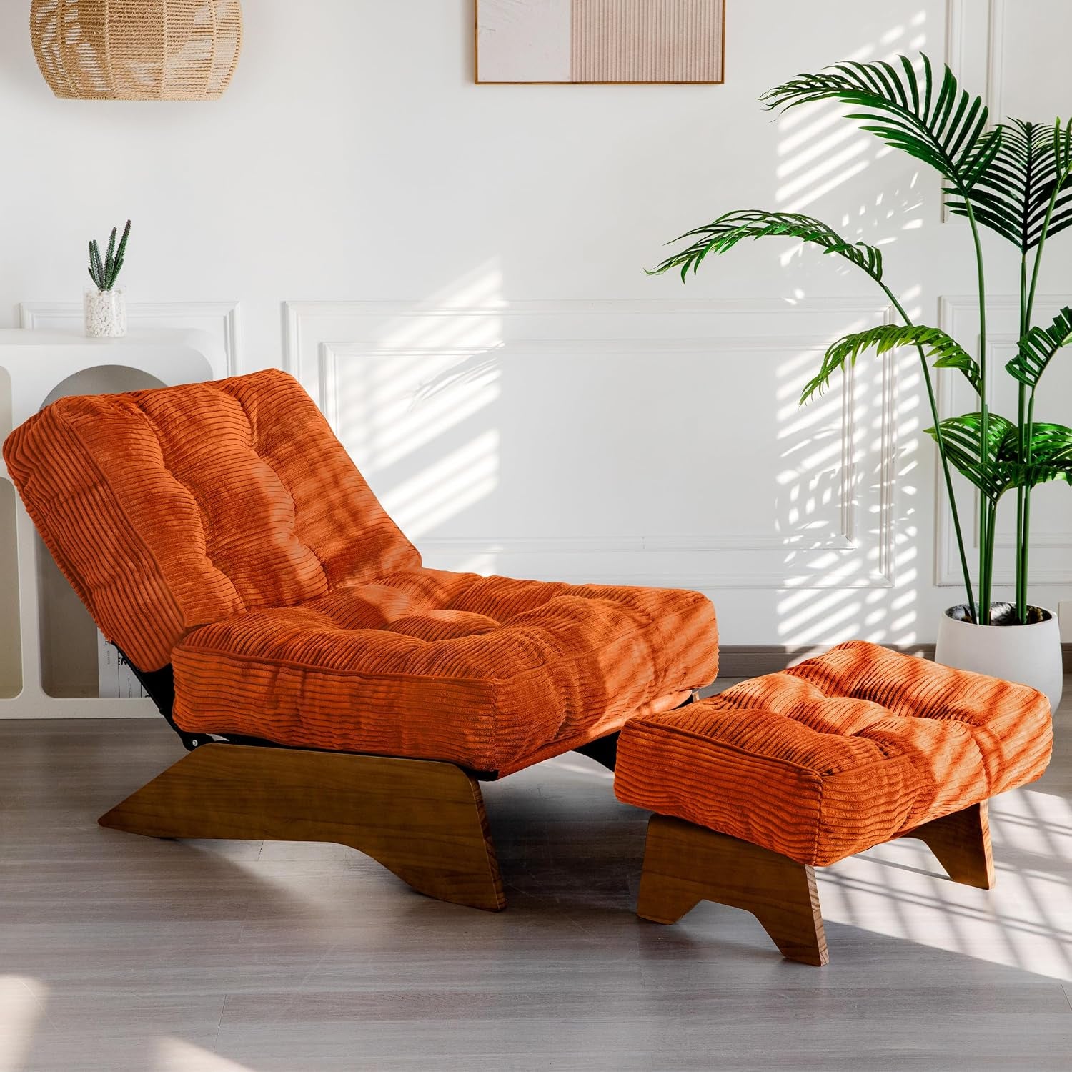 Orange corded-tufted lounge chair and matching ottoman on wooden bases in a sunlit room with a potted plant.