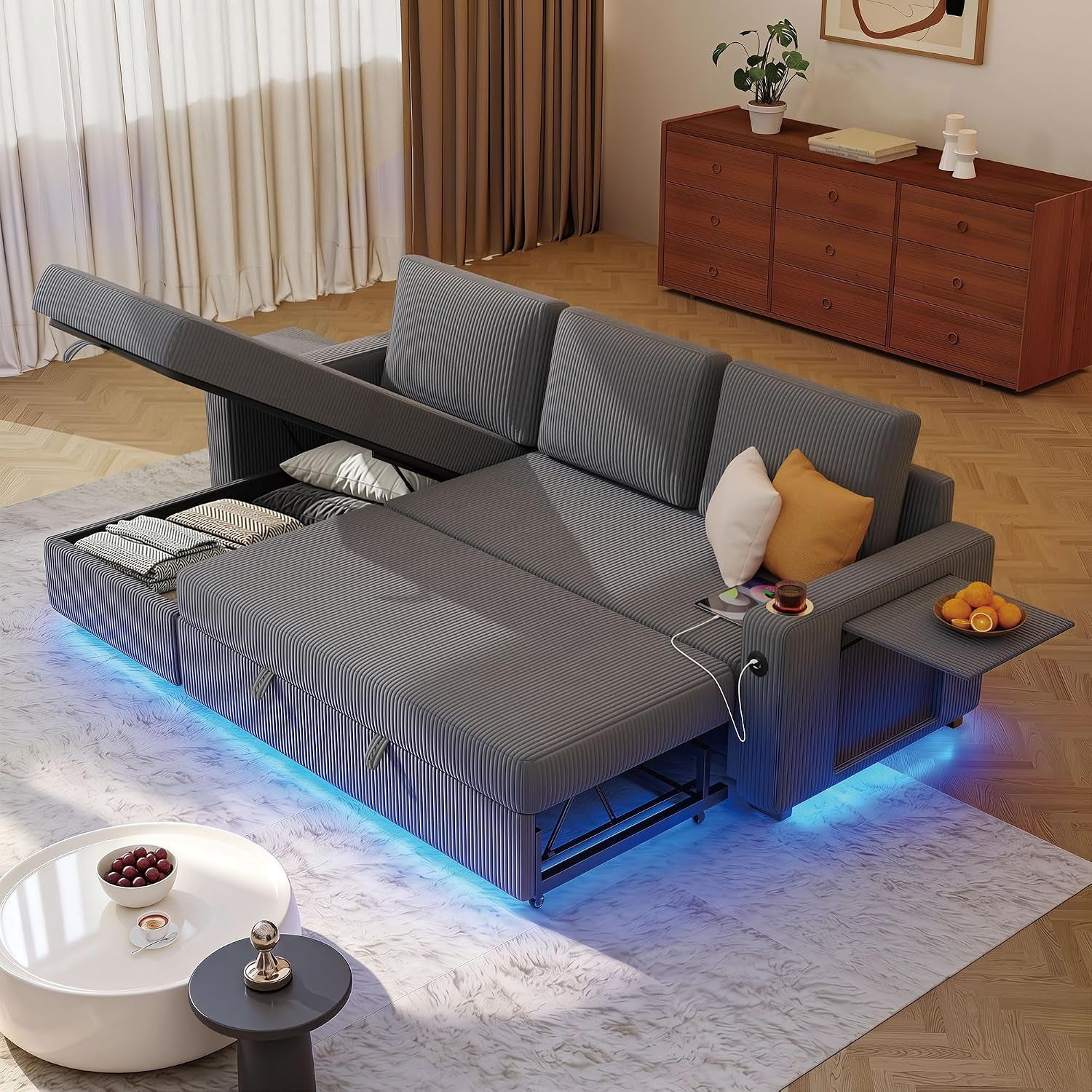 Gray corduroy L-shaped sectional opened into sleeper with under-seat storage, USB cable and blue LED base lighting.