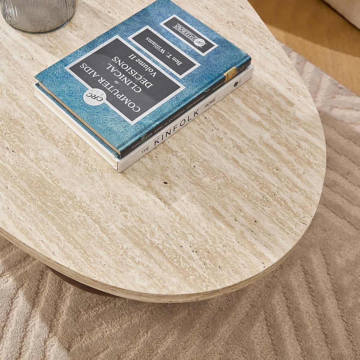 Overhead view of the oval travertine-style tabletop with a small stack of books at the center