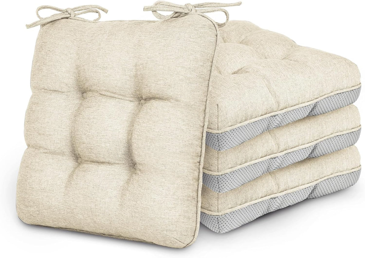 Stack of four tufted beige chair cushions with corner ties, front cushion shown upright.