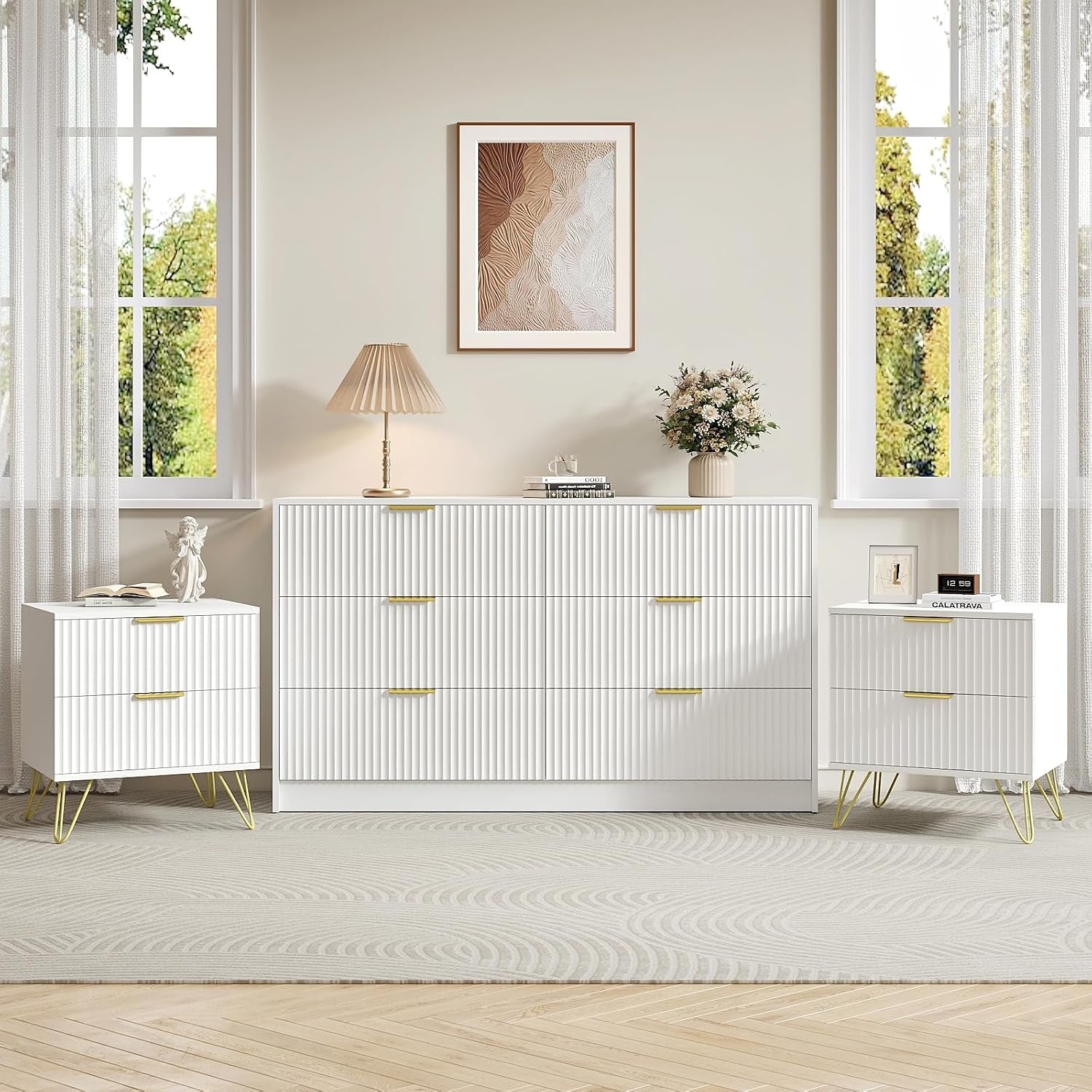 White seven-drawer dresser centered between two white two-drawer nightstands in a bright room.