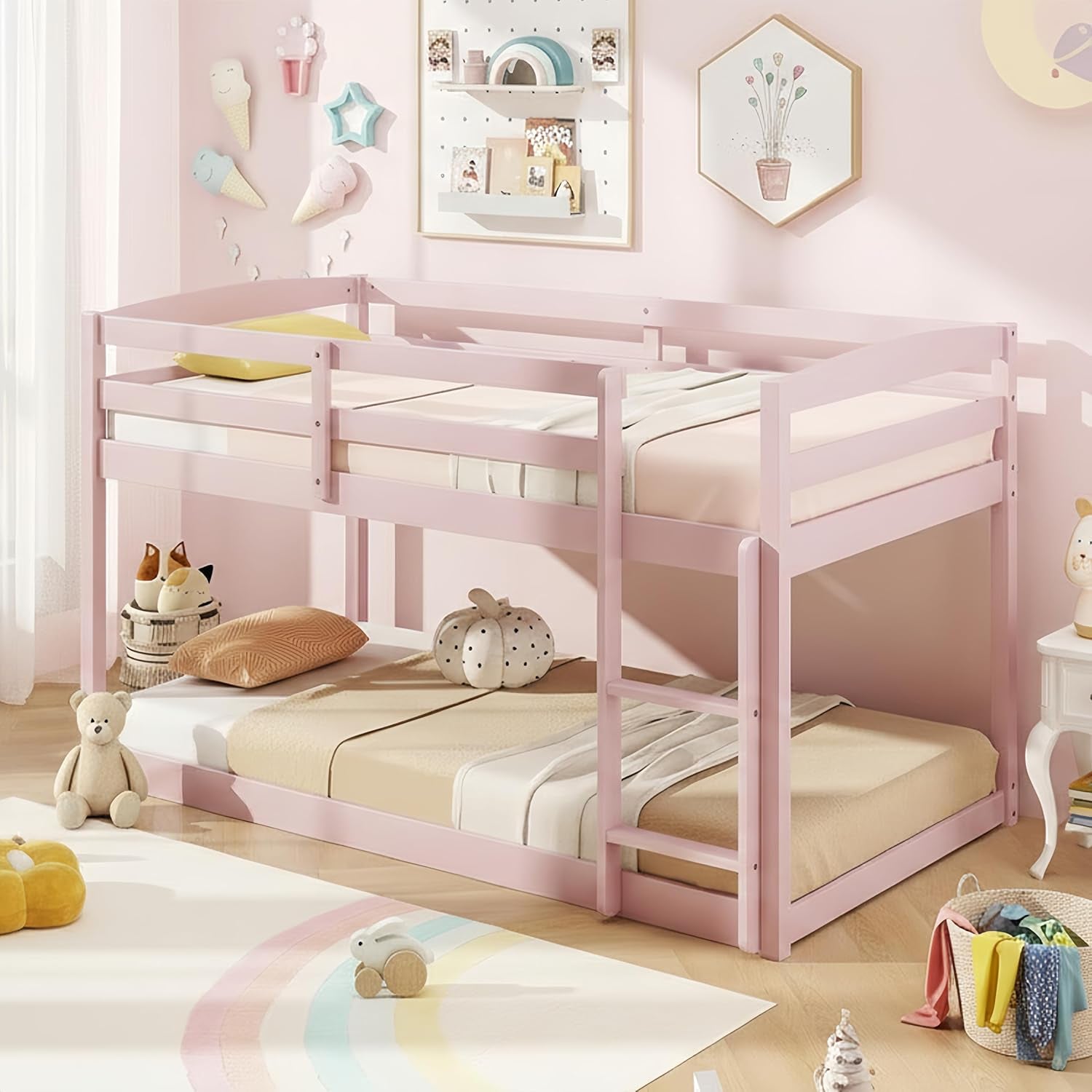 Soft pink twin-over-twin bunk bed with ladder in a pastel kids' bedroom.