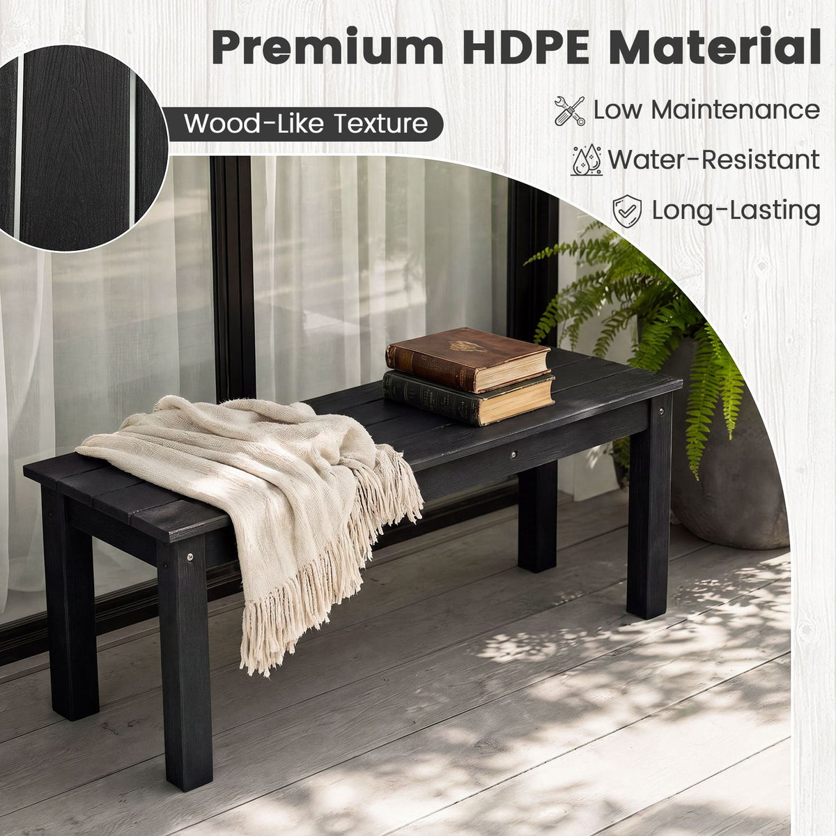 Black slatted bench with a light throw and books, showing its textured seat in a sunlit room.
