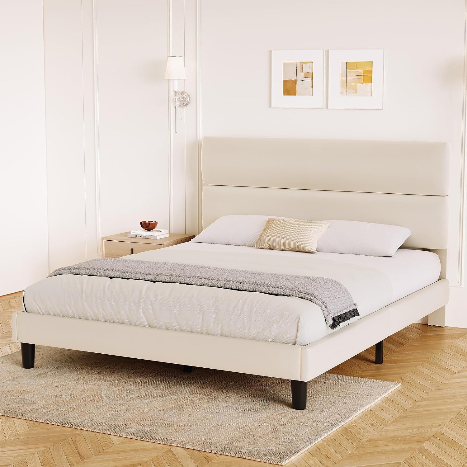 Three-quarter bedroom view of a cream platform bed with a tall two-section headboard.