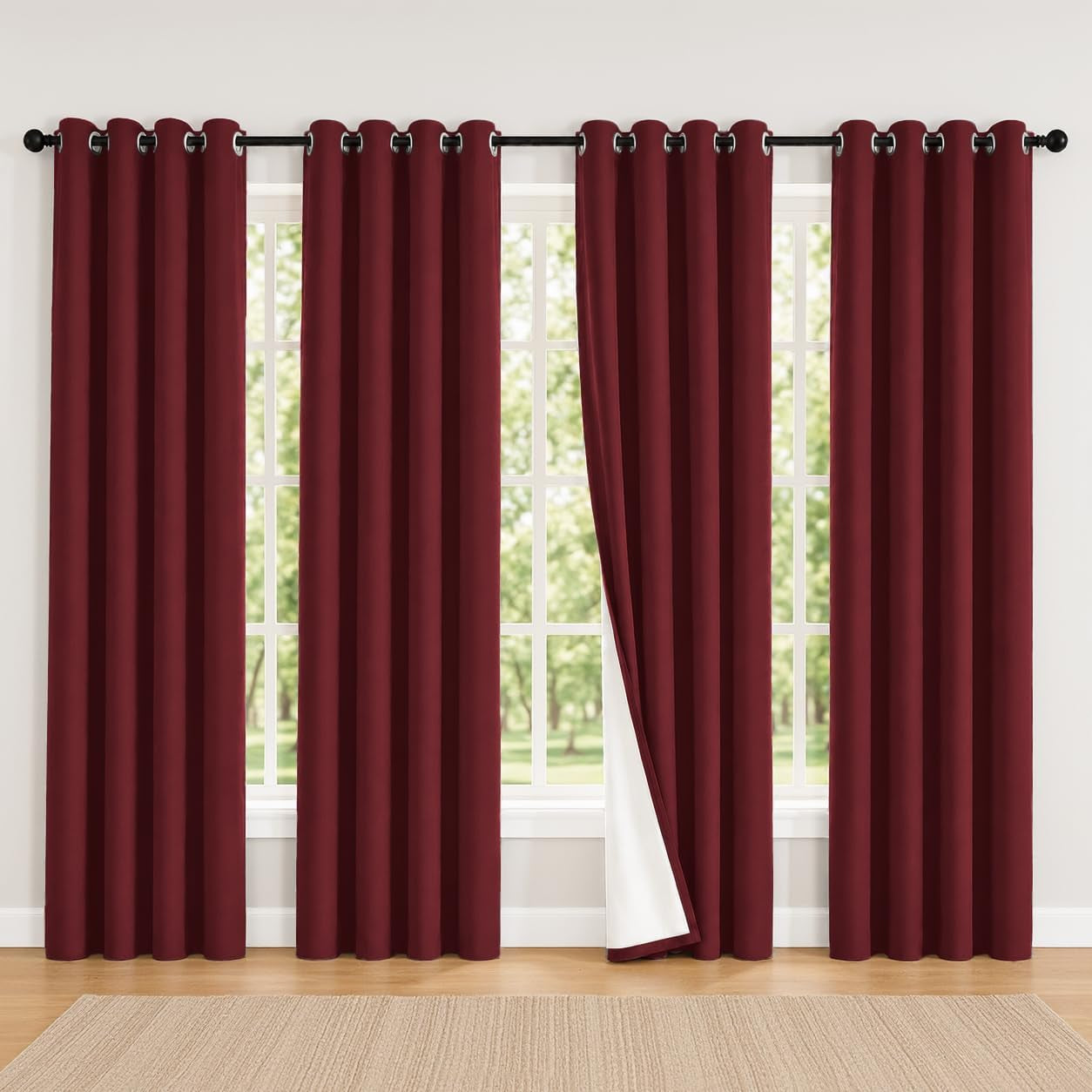Four burgundy curtain panels on a long rod with one pulled back to reveal white backing