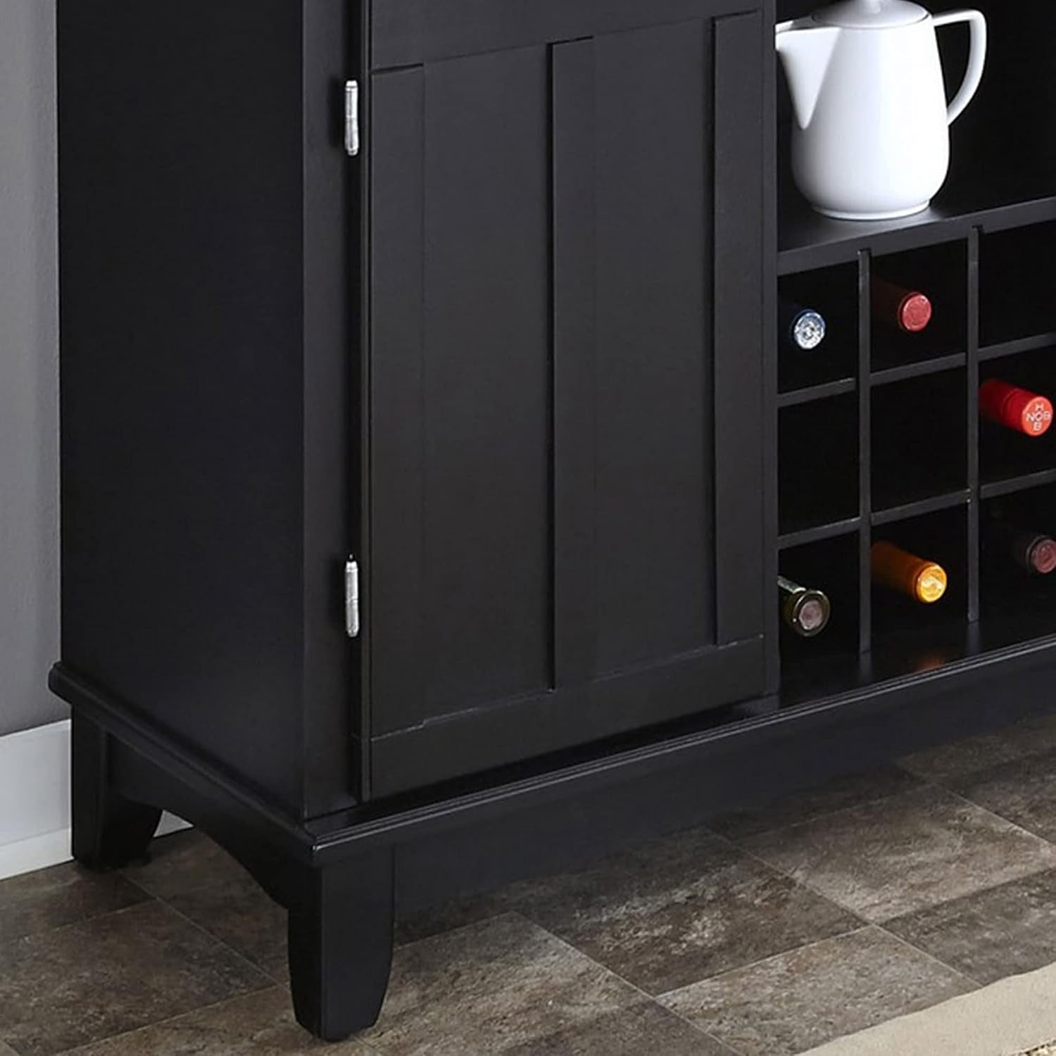 Lower cabinet detail showing paneled door, wine cubbies and tapered feet on the base