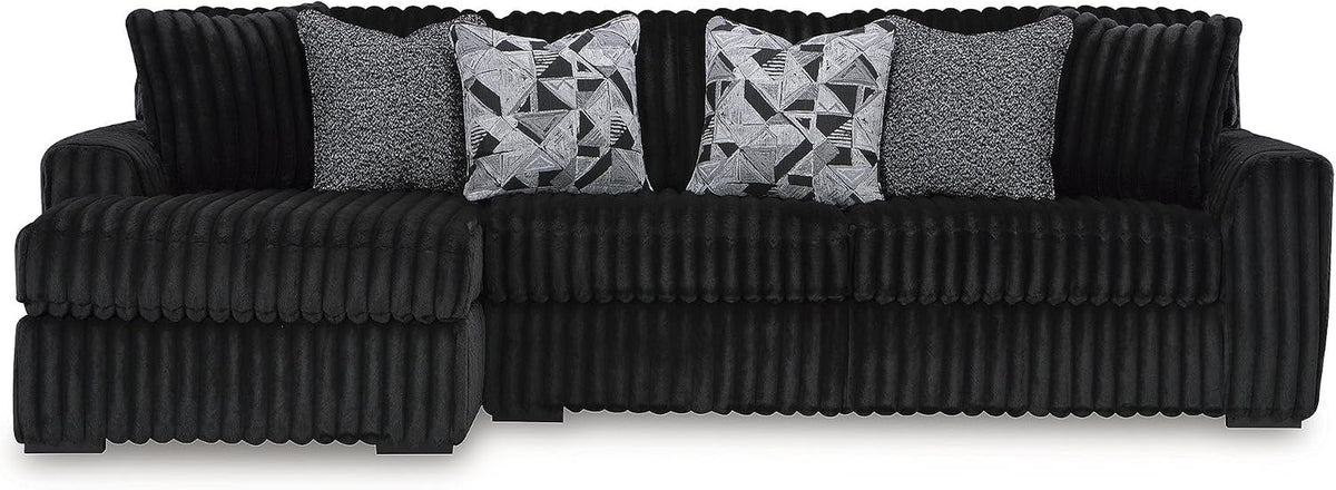 Front-facing view of a three-seat ribbed corduroy sectional sofa with four decorative pillows.