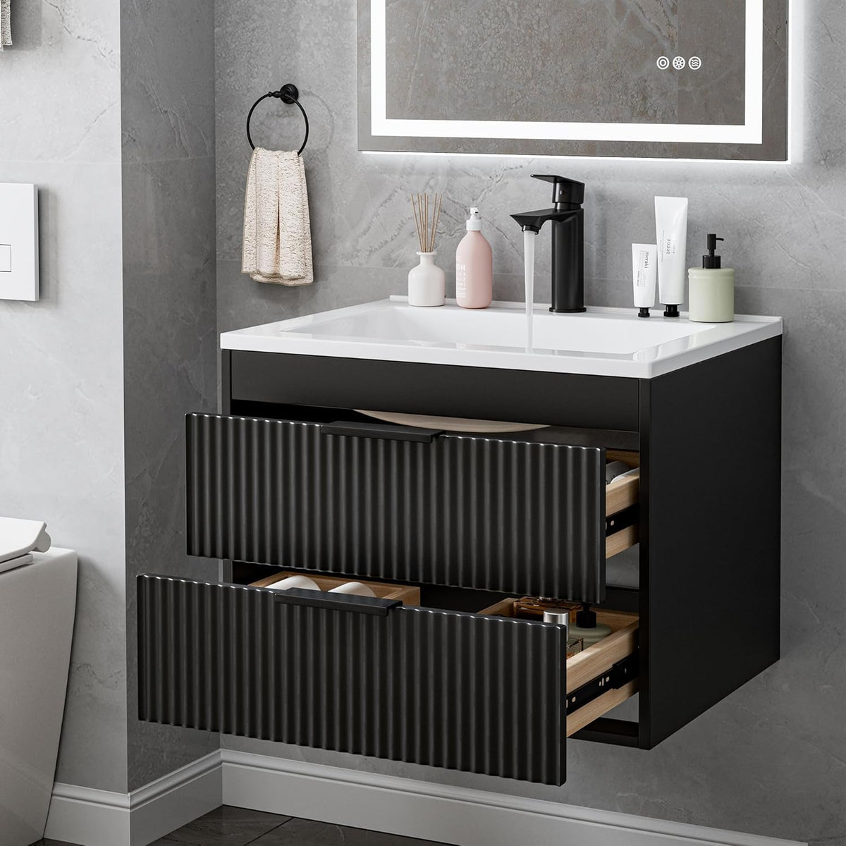 Angled view of a wall-mounted black vanity with white sink and two ribbed drawers partially open.