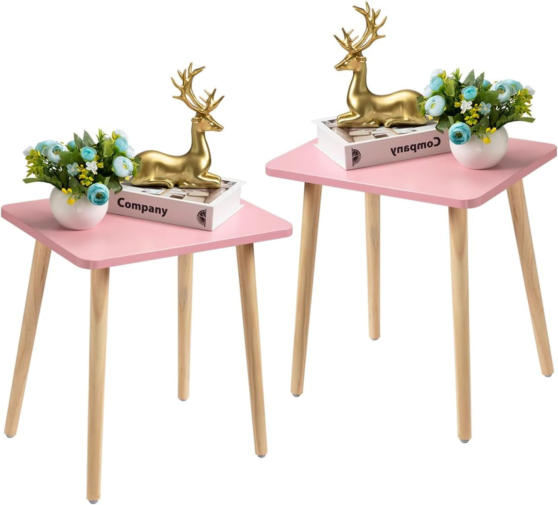 Pair of pink square side tables with light wood legs styled with book, vase and deer ornament