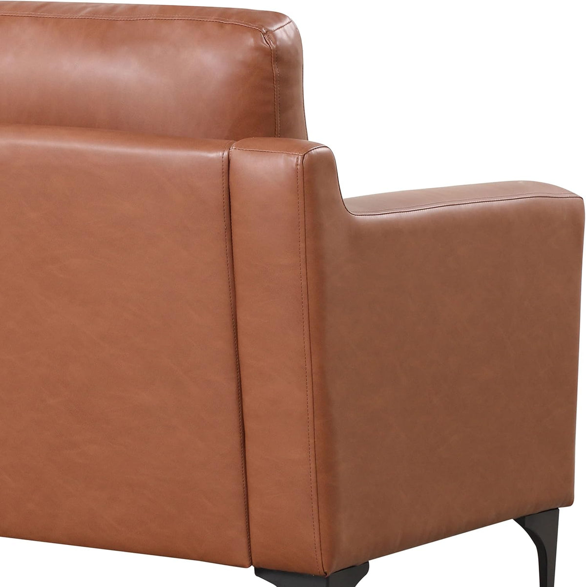 Close view of the sofa's right arm and back corner in tan faux-leather with black metal leg.