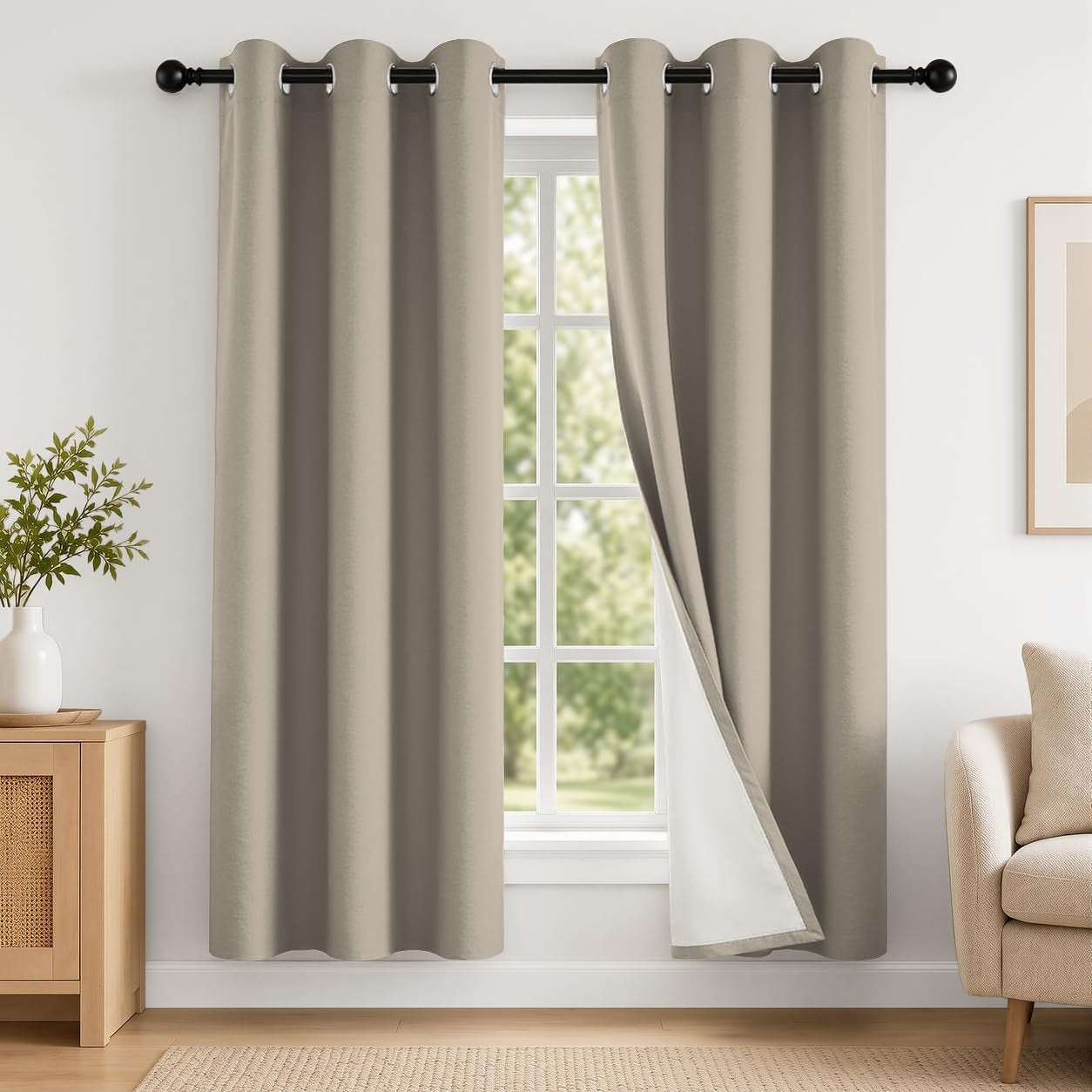 Window with two light gray-beige curtains on a black rod, right panel folded back to reveal white lining.