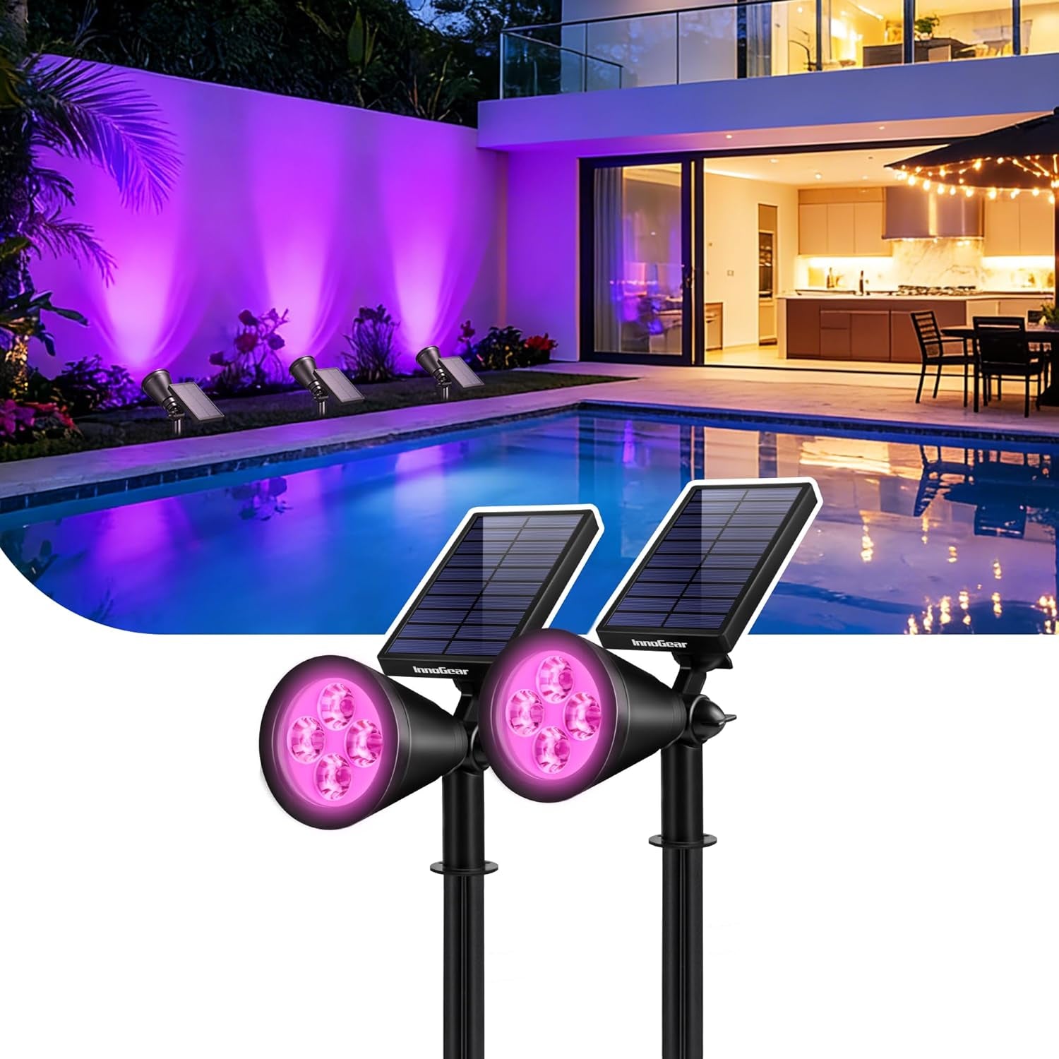 Two solar spotlights by a pool at dusk casting pinkish‑purple light on a garden wall and reflecting in the water.
