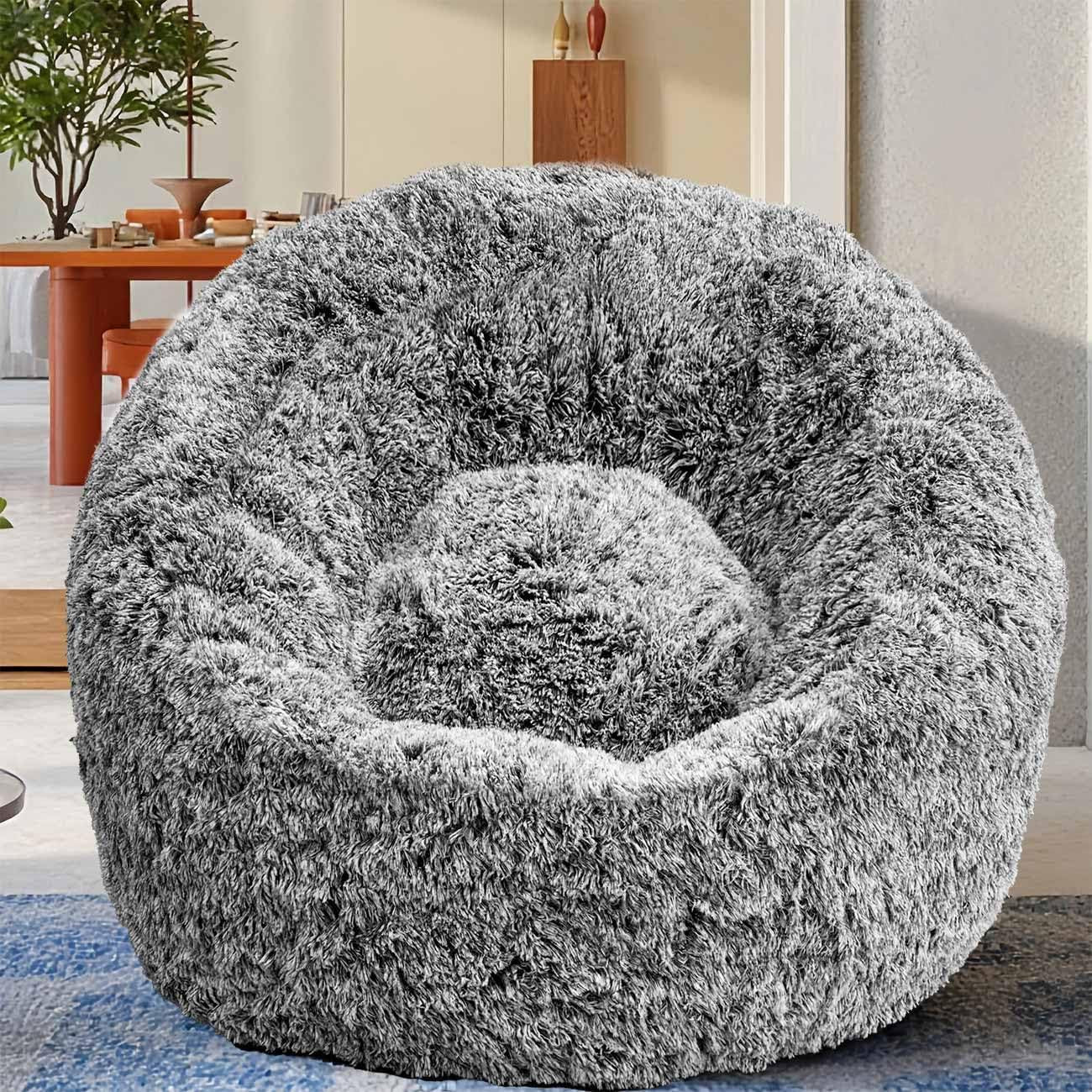 Front view of a plush gray faux-fur U-shaped bean bag chair placed on a blue rug.