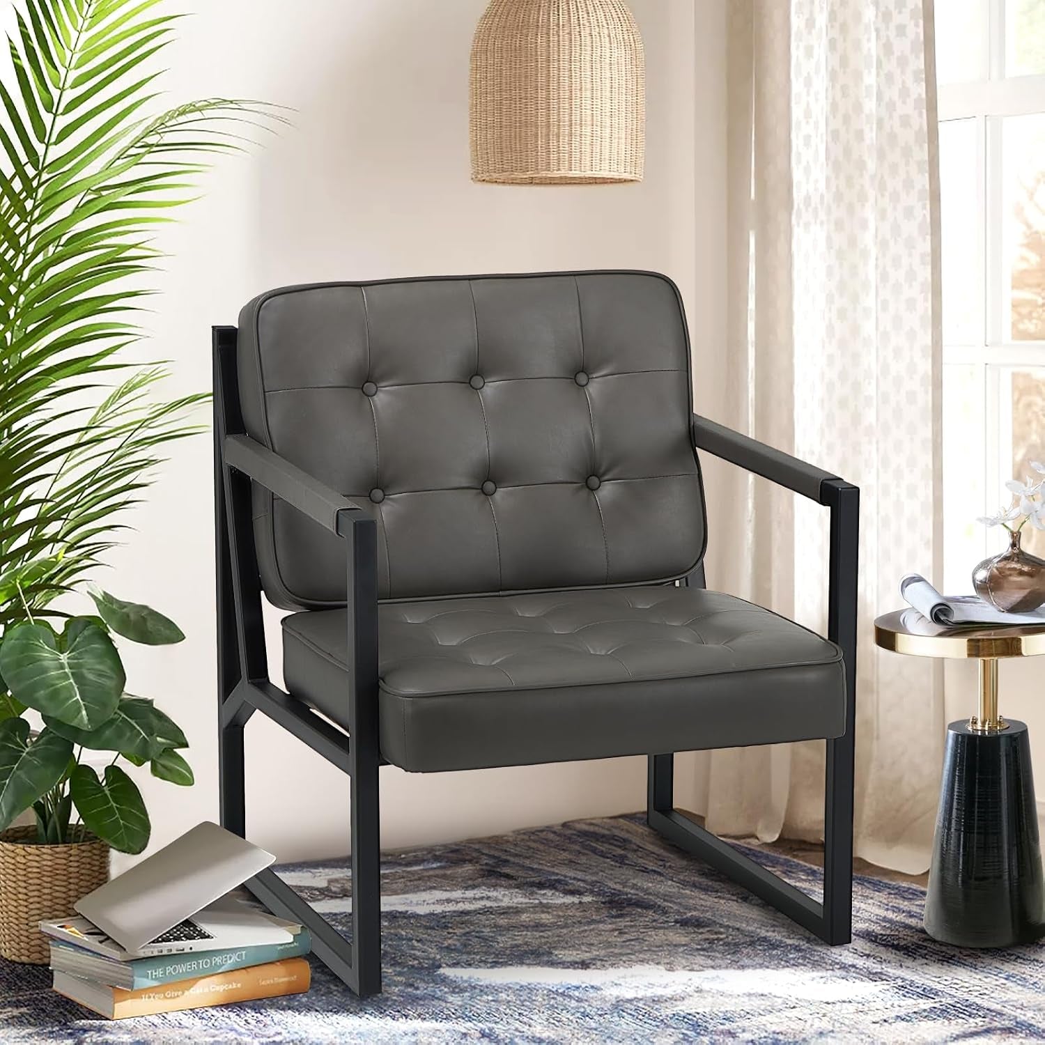 Tufted faux-leather accent chair with black metal frame in a sunlit room next to a side table and plant.