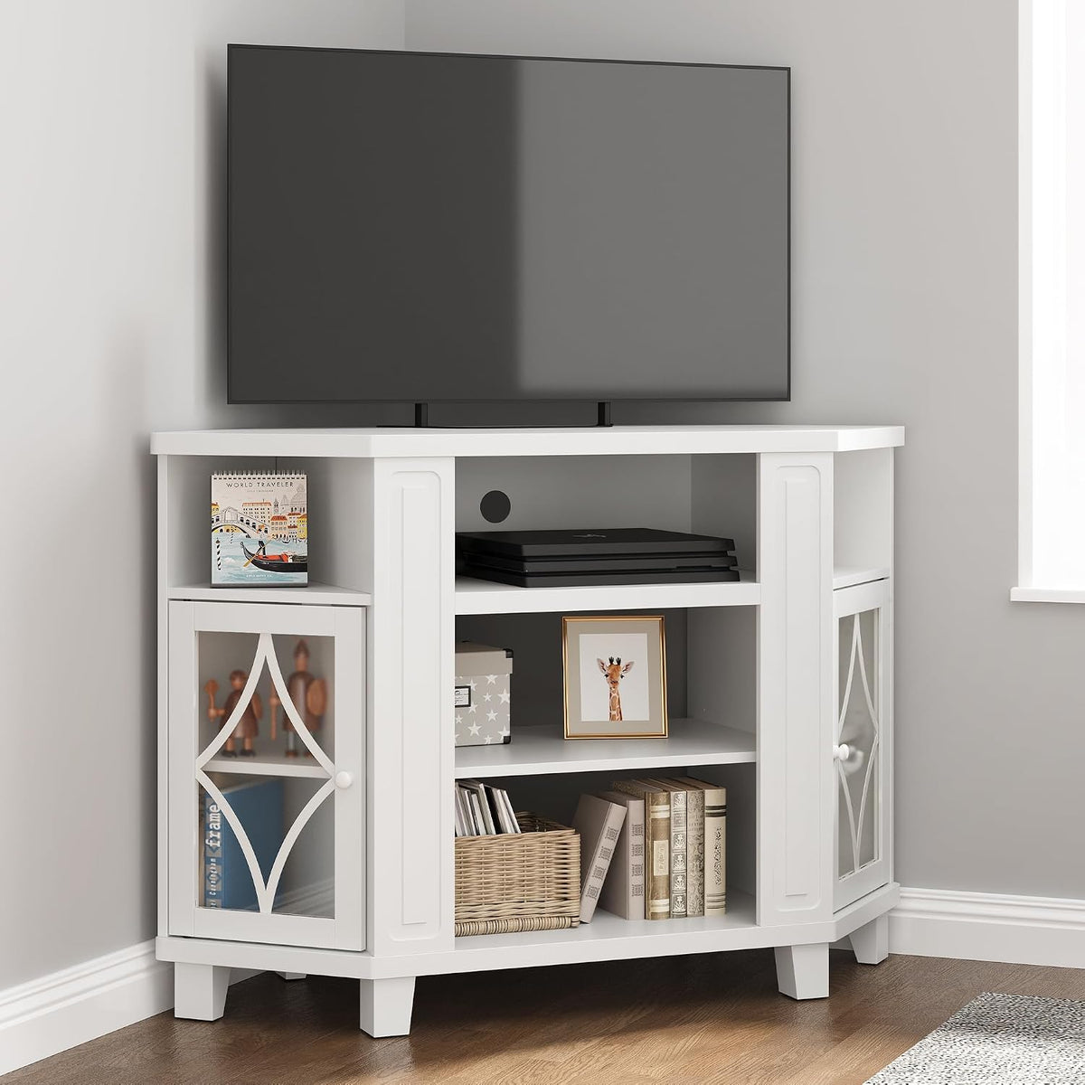 Cropped corner view of the white stand with TV, stacked consoles and framed giraffe on middle shelf.