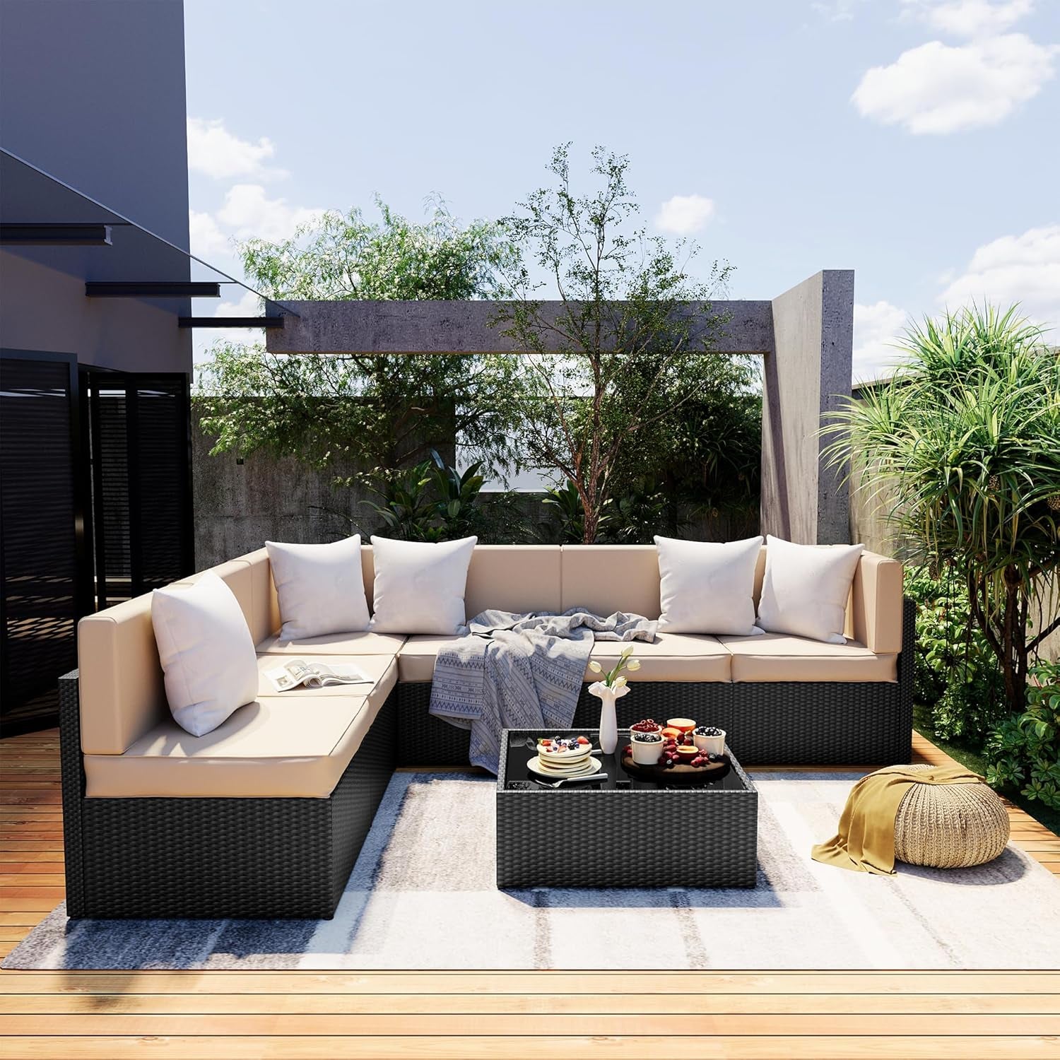 Outdoor L-shaped dark rattan 7-piece sectional with beige cushions on a wood deck, angled front view