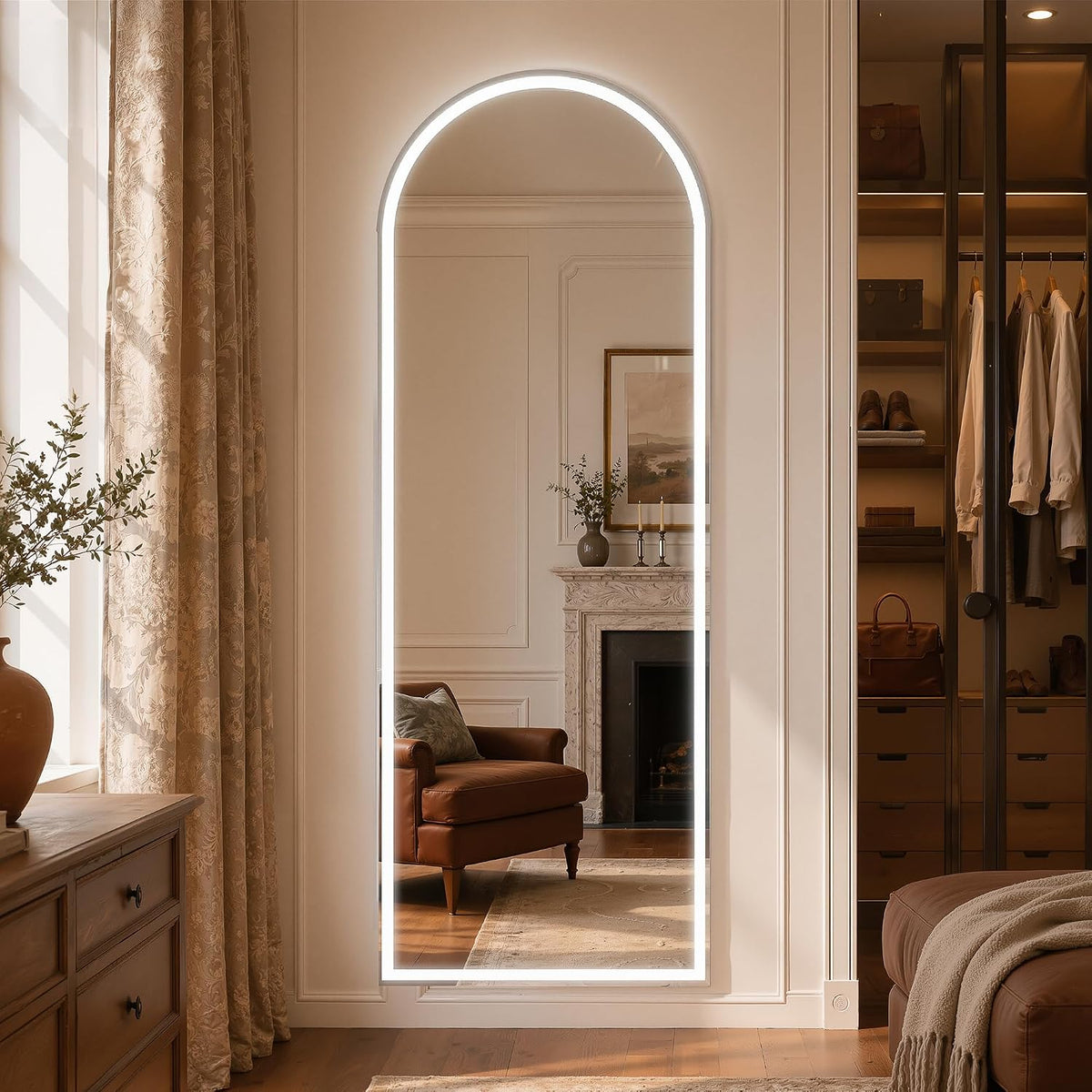 Wall-mounted arched full-length mirror with an illuminated LED border in a softly lit bedroom and wardrobe scene