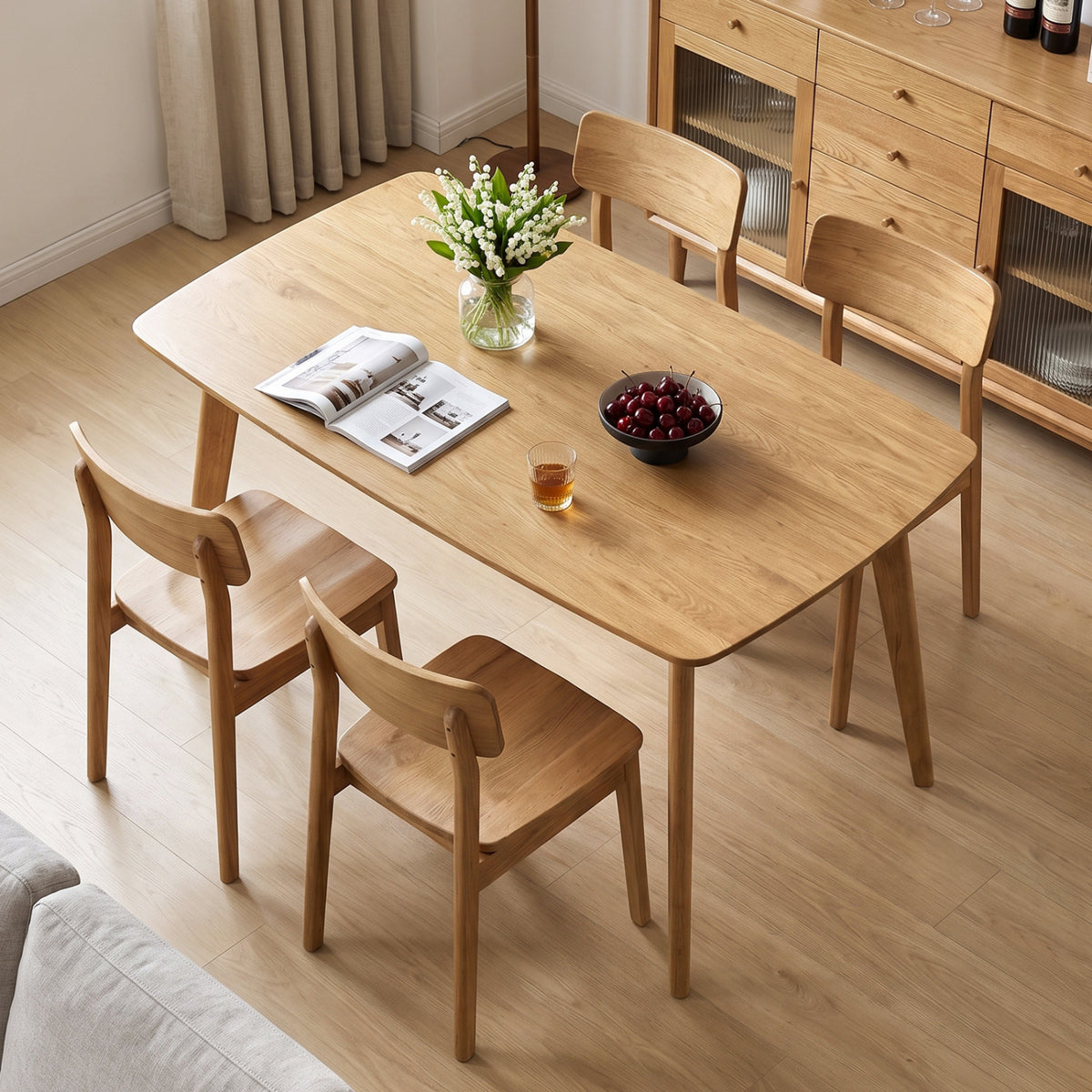 Natural wood dining table set with chairs in a dining room, viewed from above