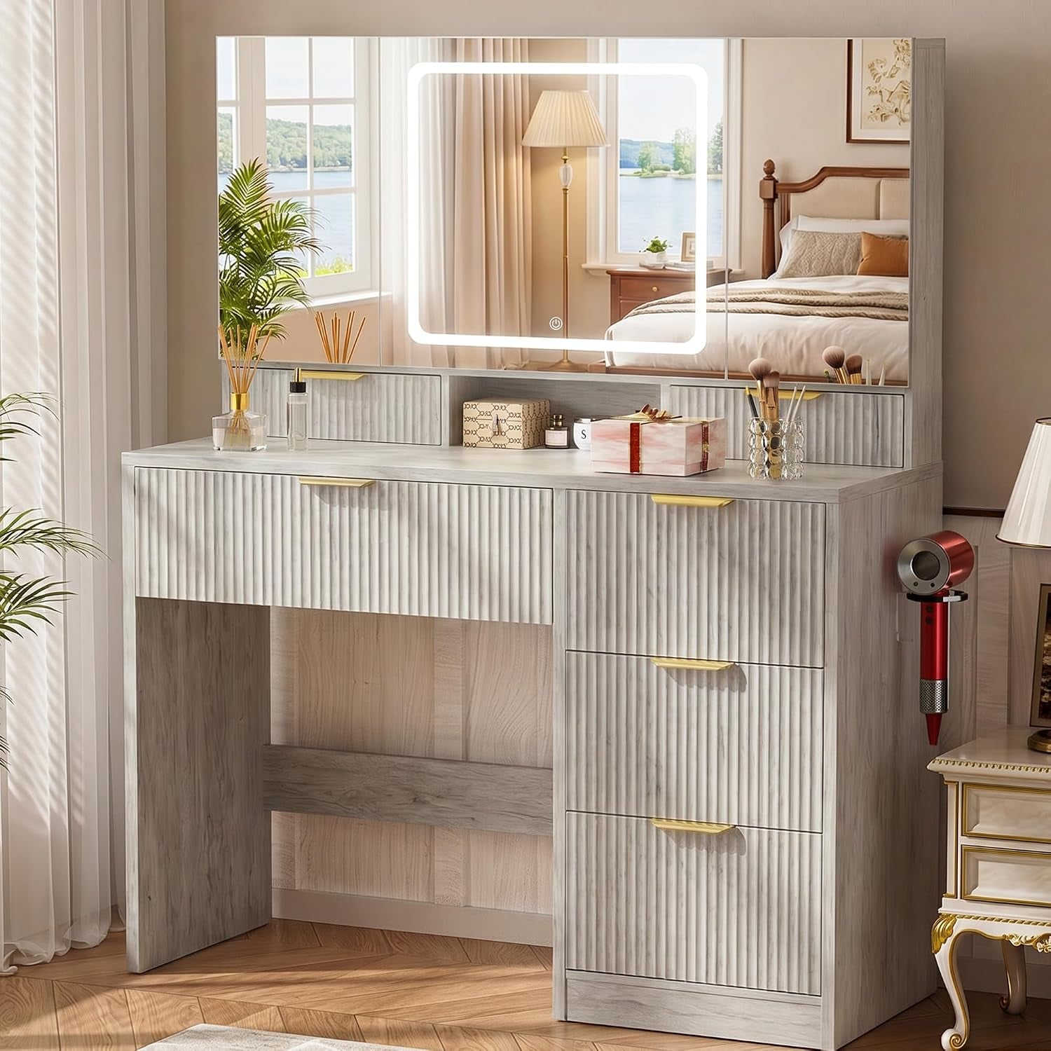 Front view of a ribbed wood vanity with a large lighted mirror, tabletop accessories and three right-side drawers.