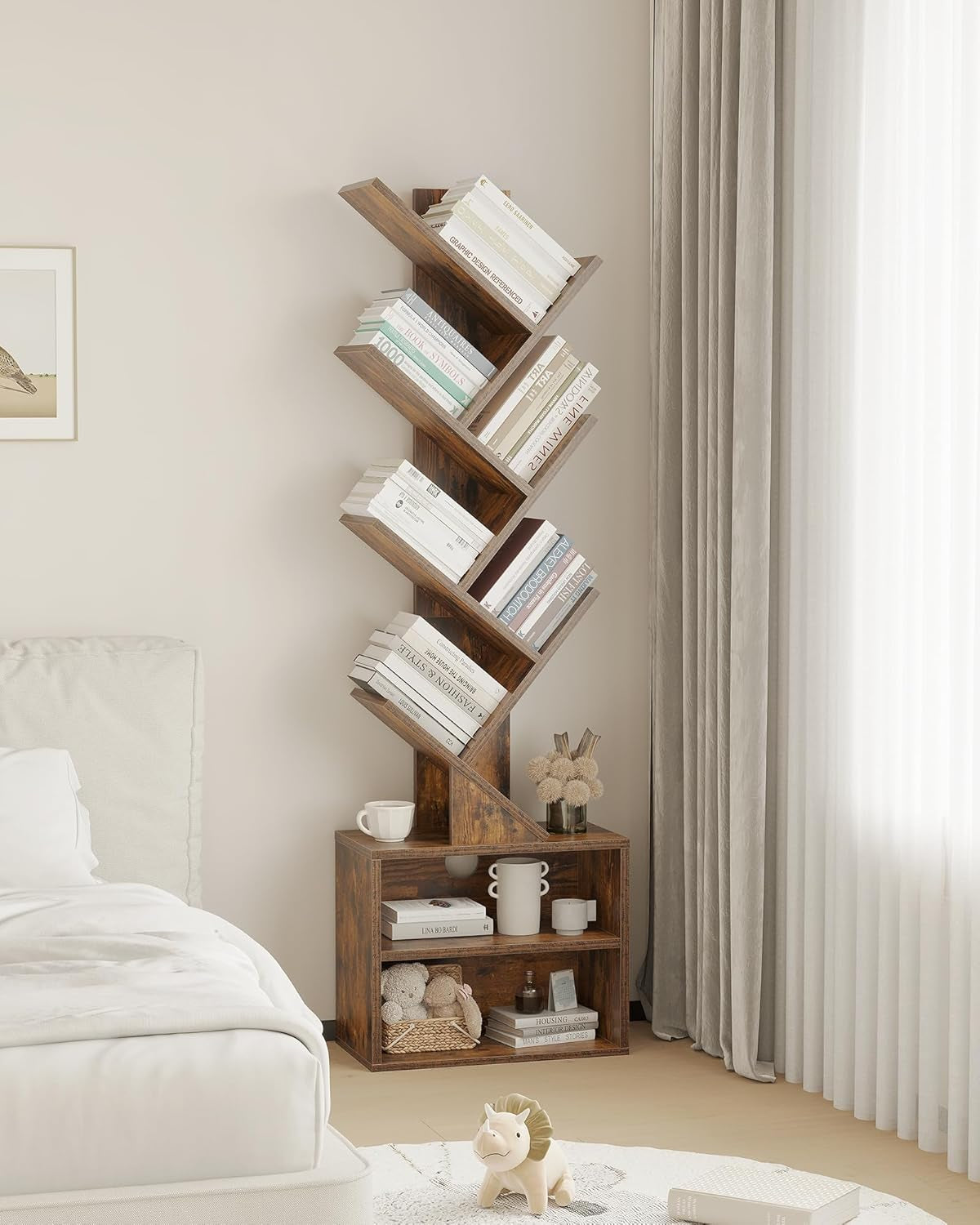Full-height tree bookshelf staged beside a bed and curtains, filled with books and decorative items on its lower cubbies.