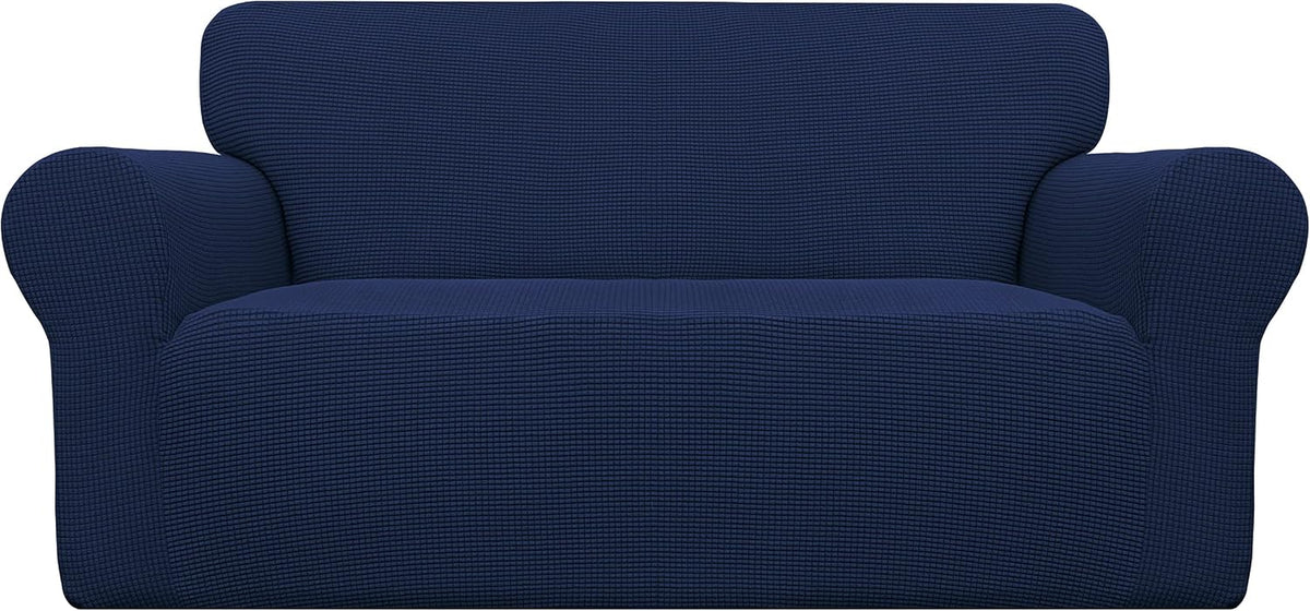 Front view of a loveseat dressed in a deep navy textured stretch slipcover on a plain backdrop
