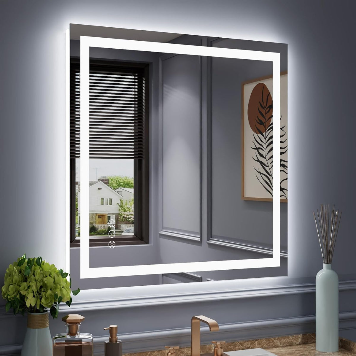 Illuminated square LED mirror reflecting a window and artwork, with faucet, countertop decor and a small potted plant below.