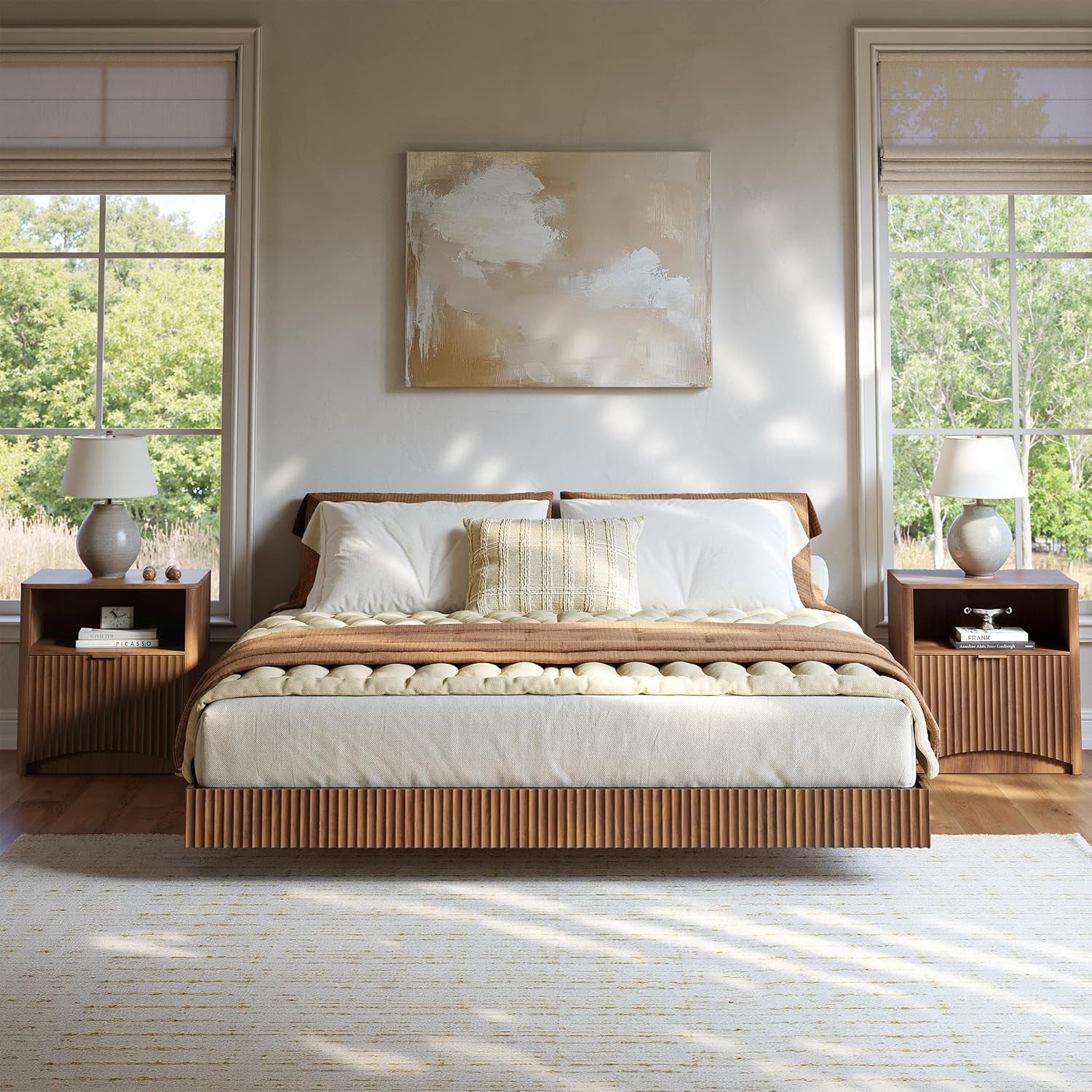 Centered floating bed with ribbed wood base and paired fluted nightstands by tall windows