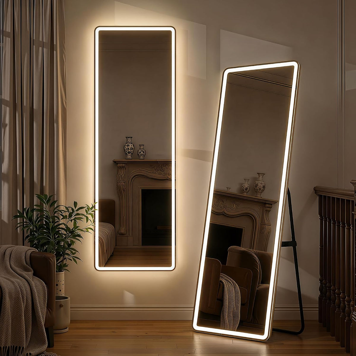 Wall-mounted rectangular LED floor mirror beside a leaning illuminated mirror; plant, armchair edge and fireplace reflected.