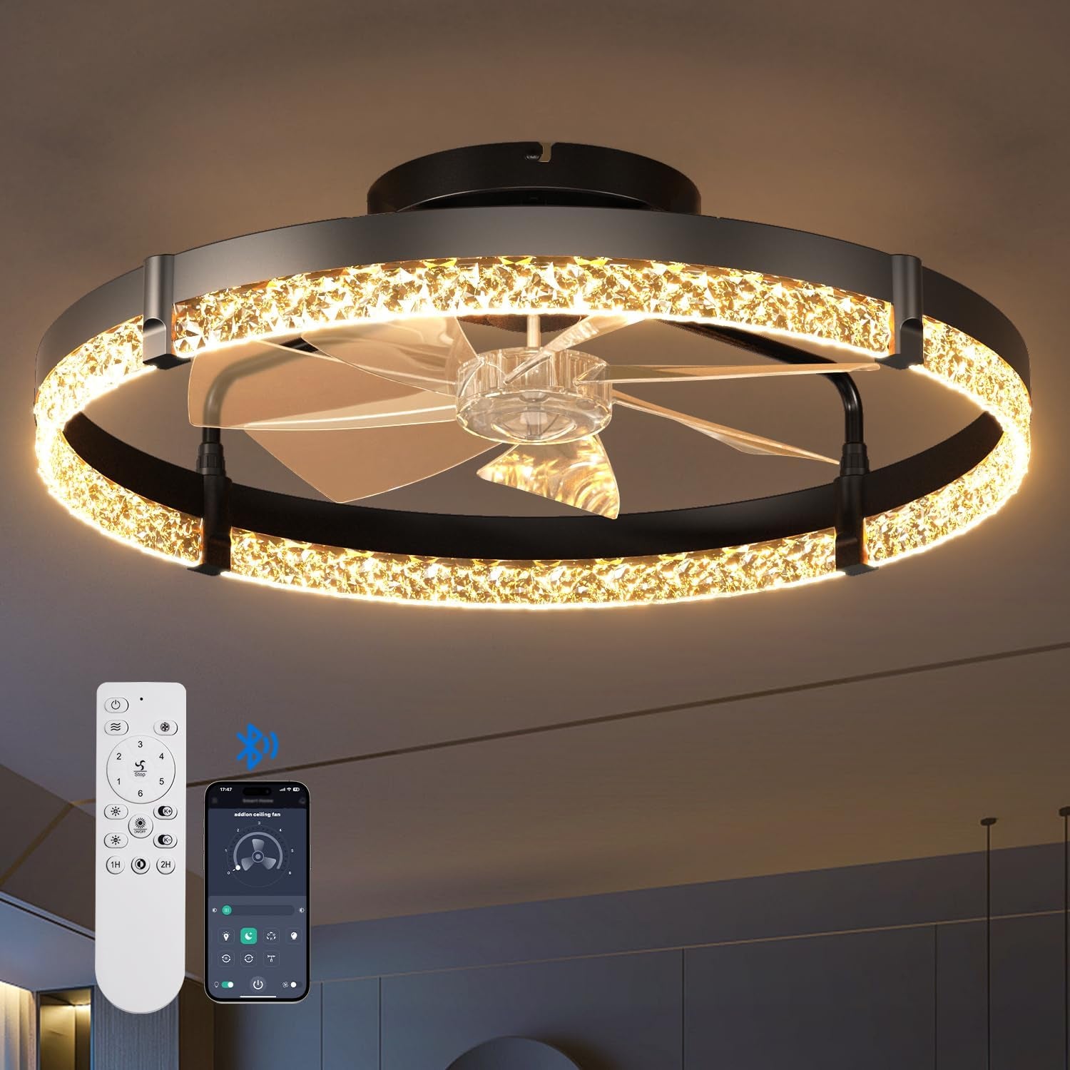 Black ring fandelier lit warm with a sparkling crystal-like inner band and clear blades, remote and phone at lower left.