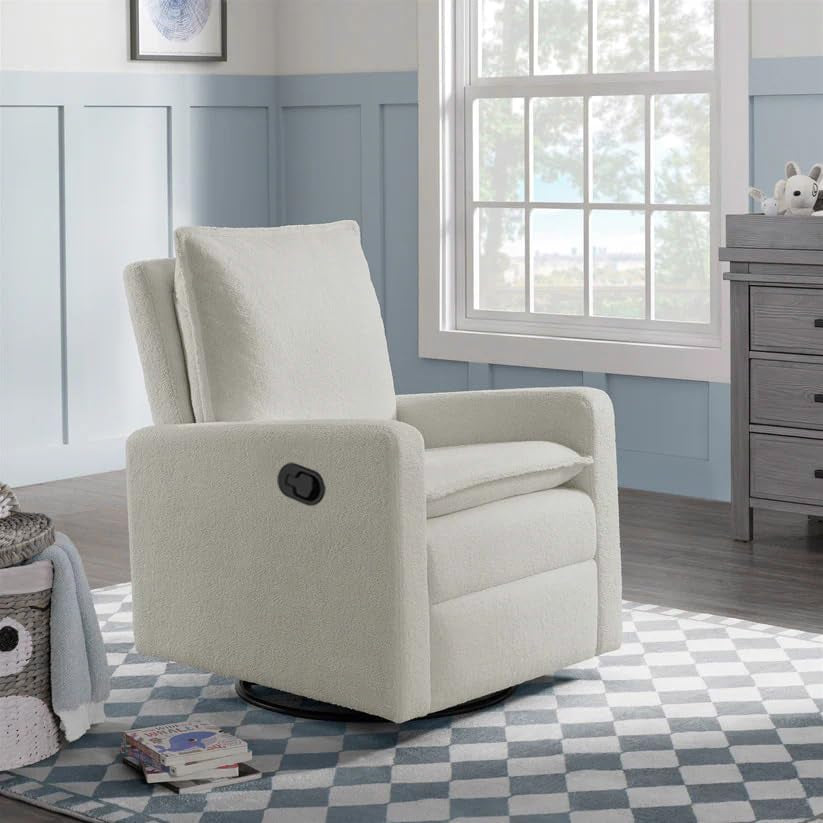 White boucle glider placed in a nursery setting on a patterned rug next to a window and dresser.