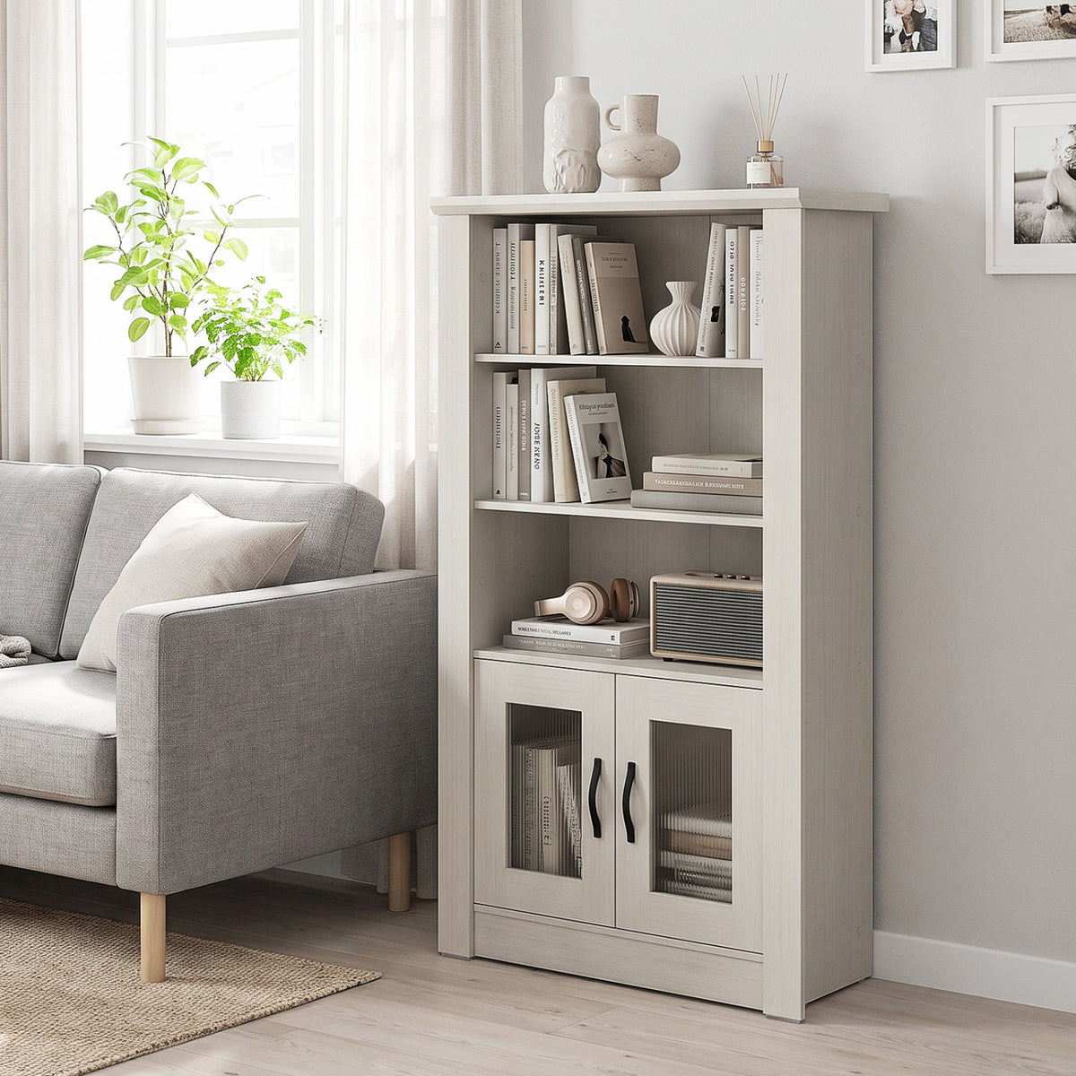 White bookcase beside a gray sofa, with books and decor on its shelves.