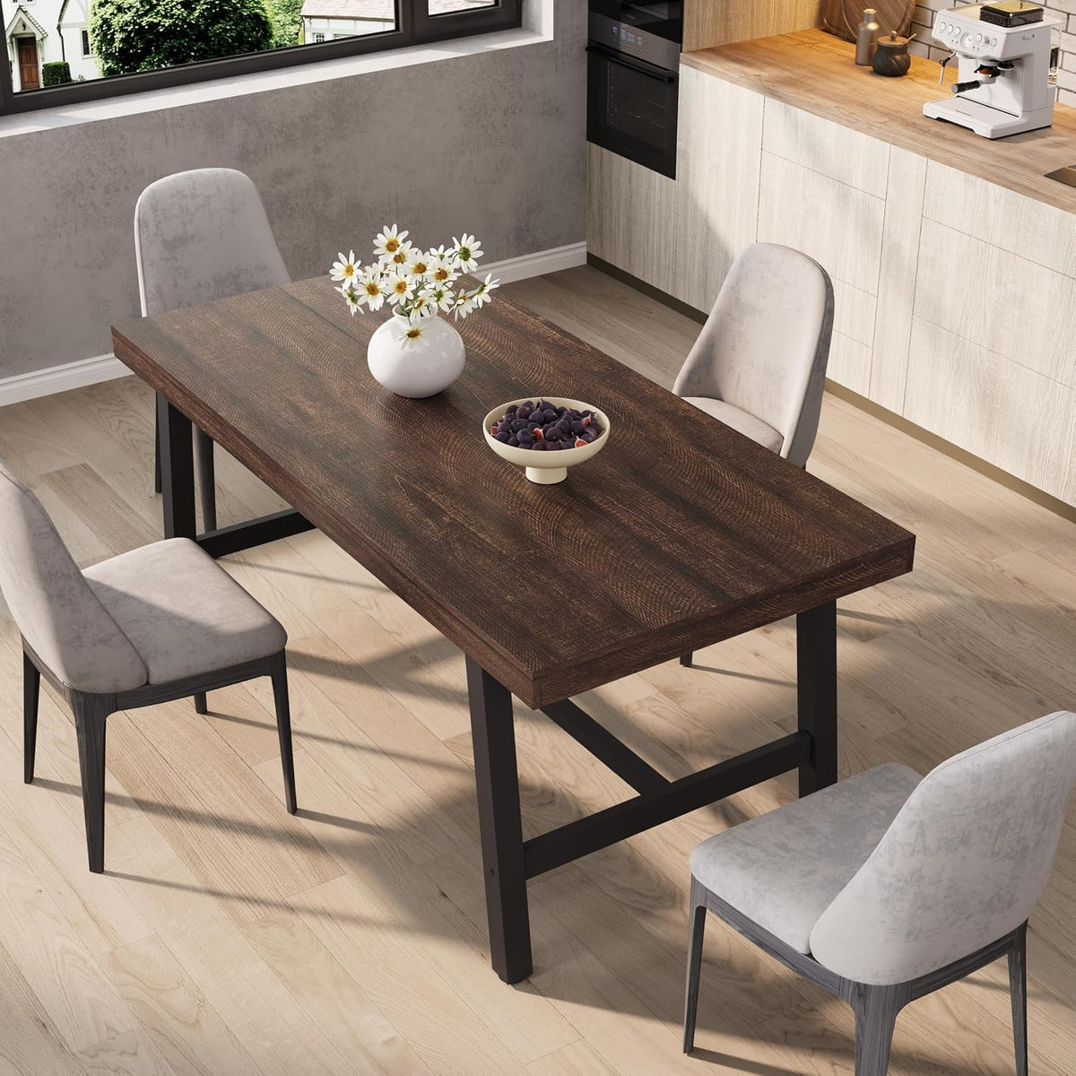 Three-quarter view of the table in a dark wood finish with black metal base and decorative bowl and vase.