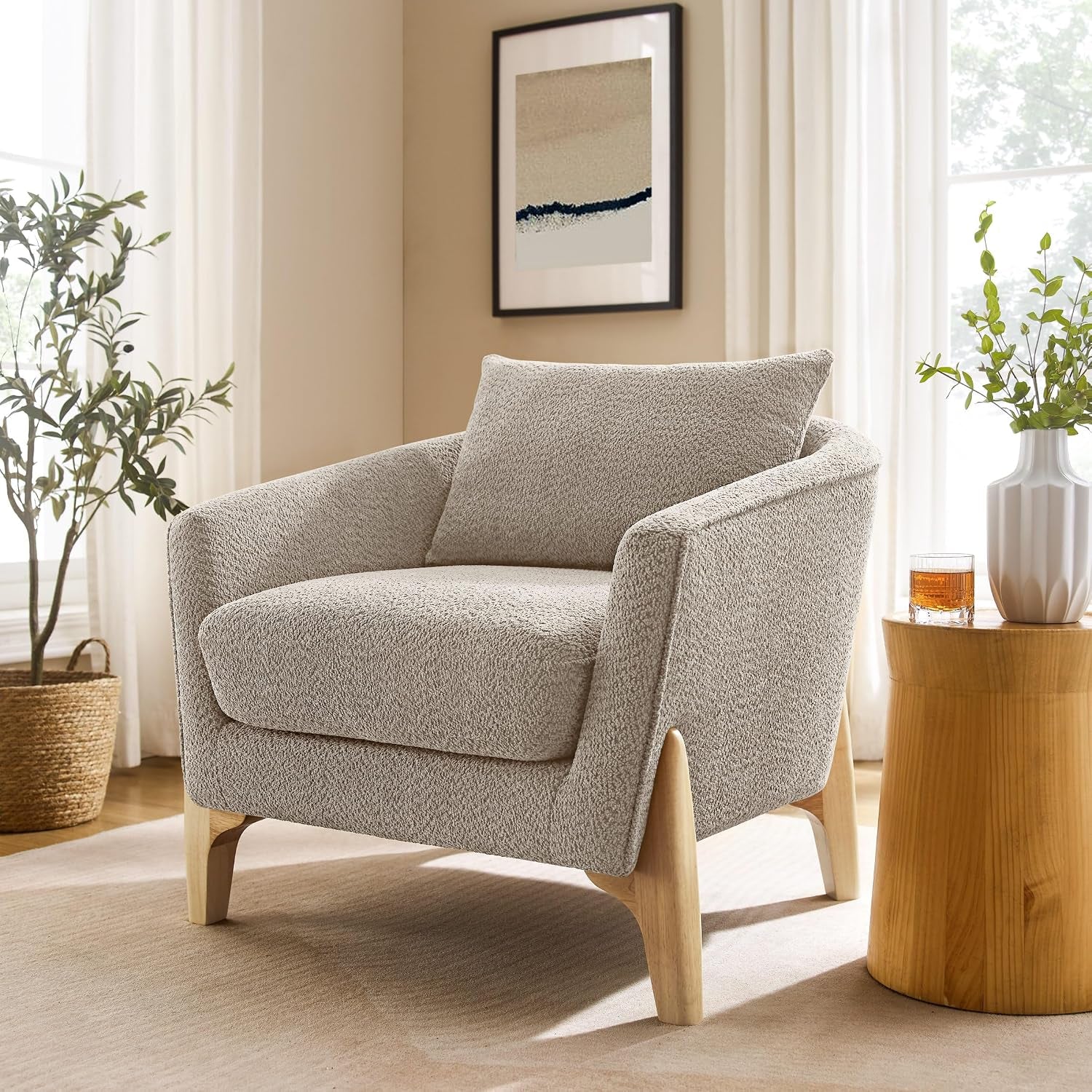 Single light gray oversized fleece accent chair with a loose back cushion and visible light wood frame in a bright room.