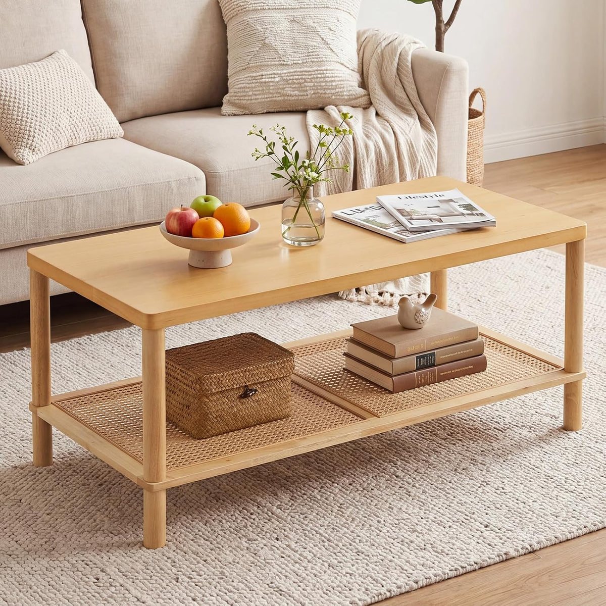 Rectangular light-wood coffee table with fruit bowl and woven lower shelf in a bright room