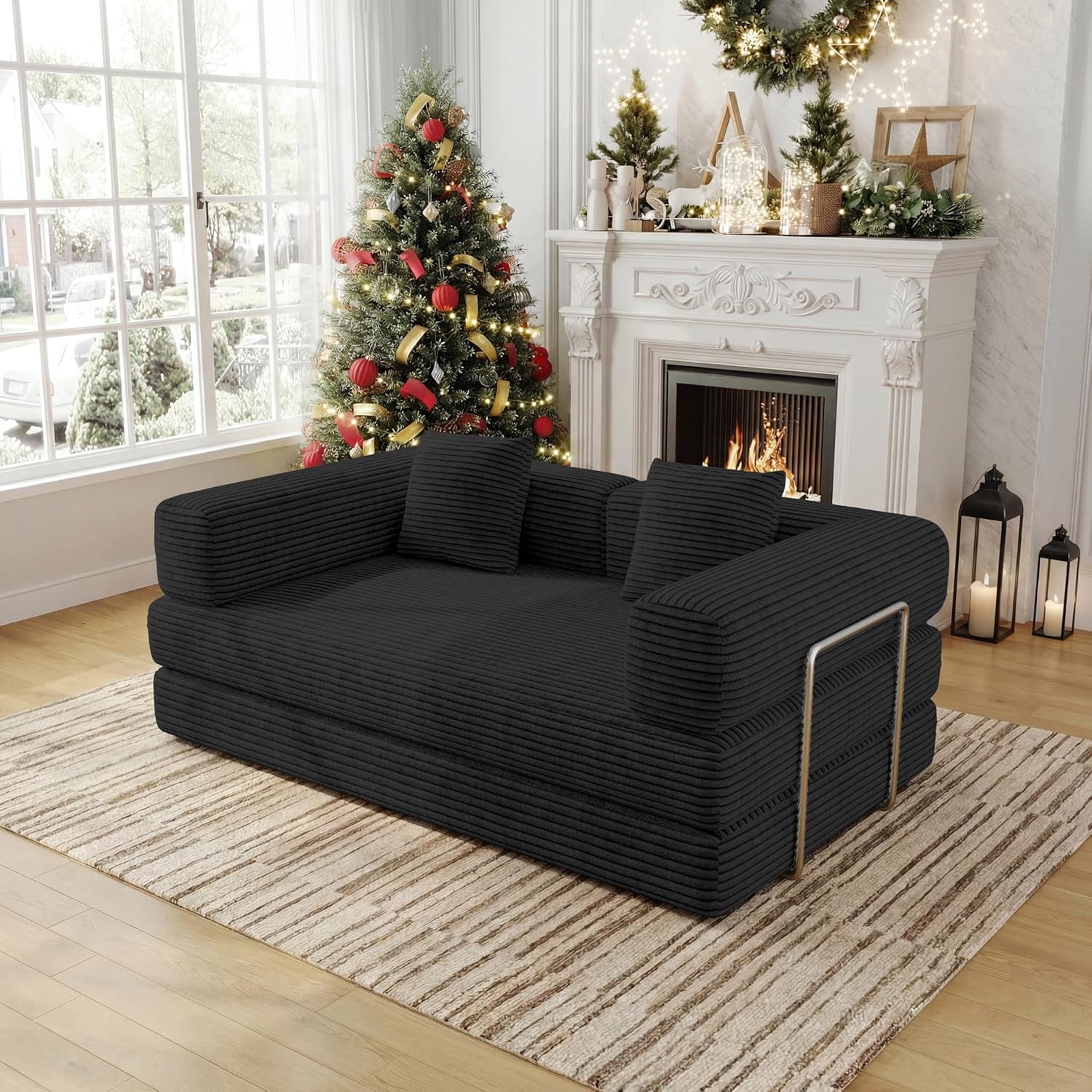 Black corduroy convertible sofa arranged as a compact two-seat couch with metal side frame by a fireplace.