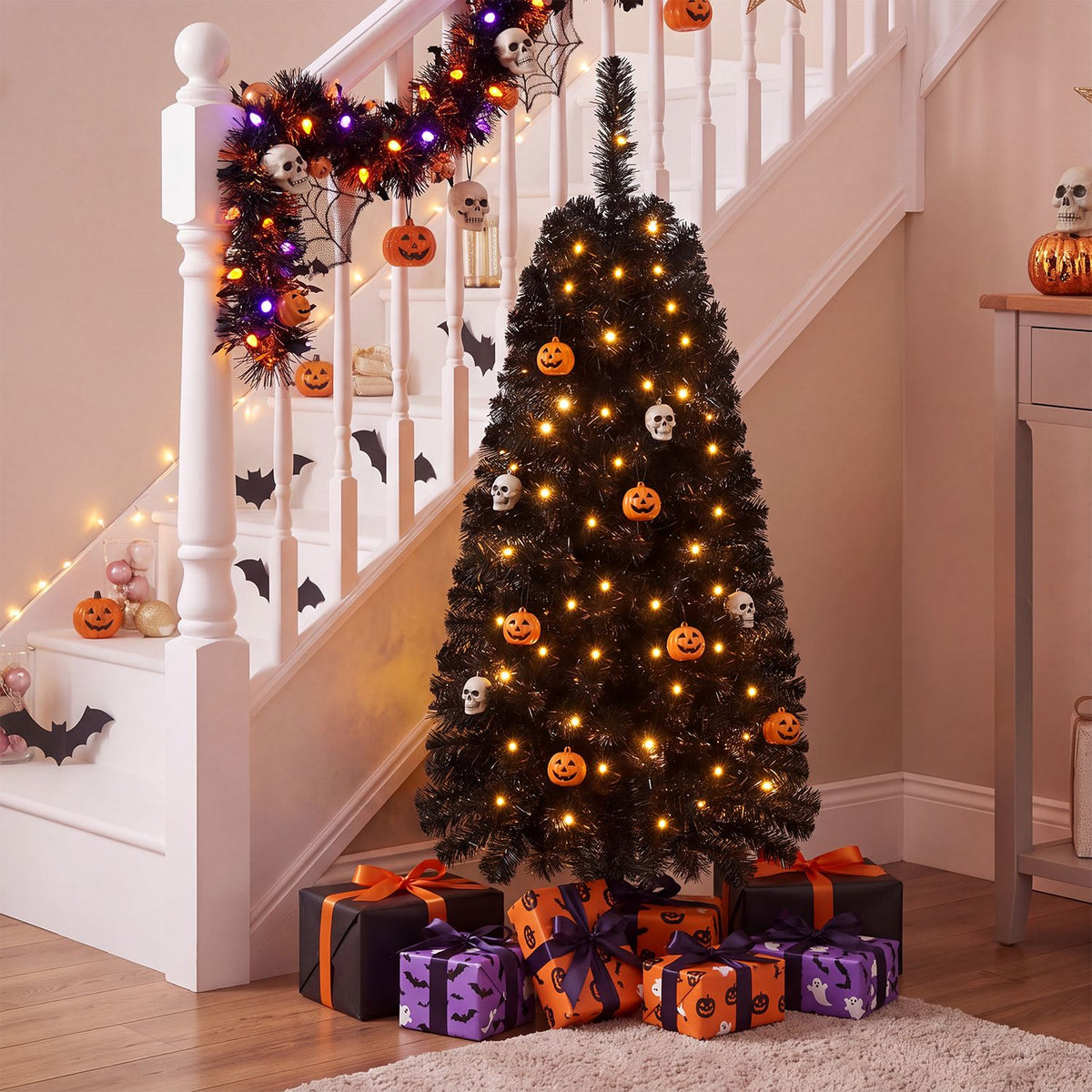 Glowing artificial tree with pumpkin and skeleton ornaments beneath a decorated staircase.